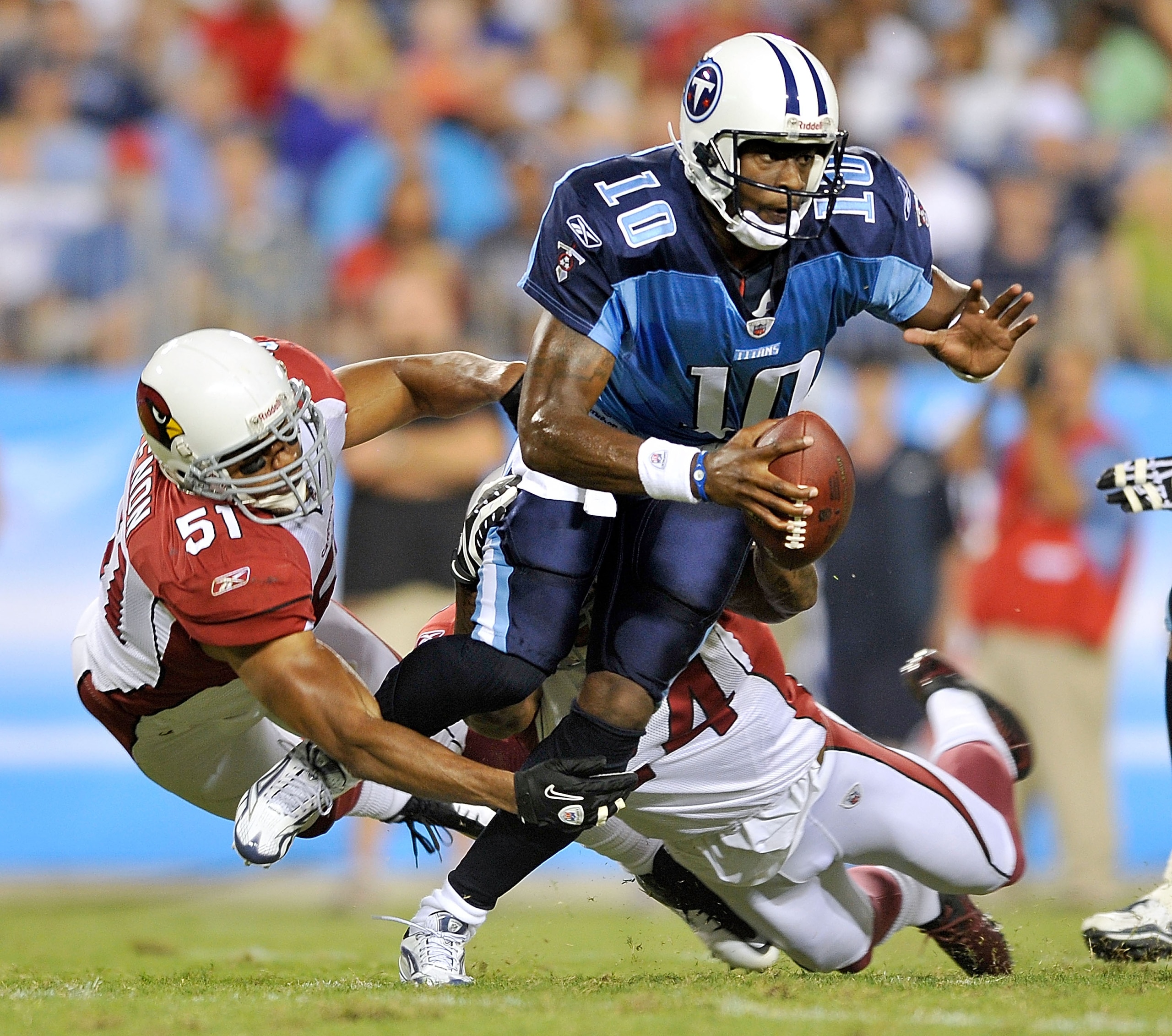 NASHVILLE, TN - AUGUST 23:  Vince Young #10 of the Tennessee Titans scrambles away from Paris Lenon #51 and Adrian Wilson #24 of the Arizona Cardinals during the first half of a preseason game at LP Field on August 23, 2010 in Nashville, Tennessee.  (Phot