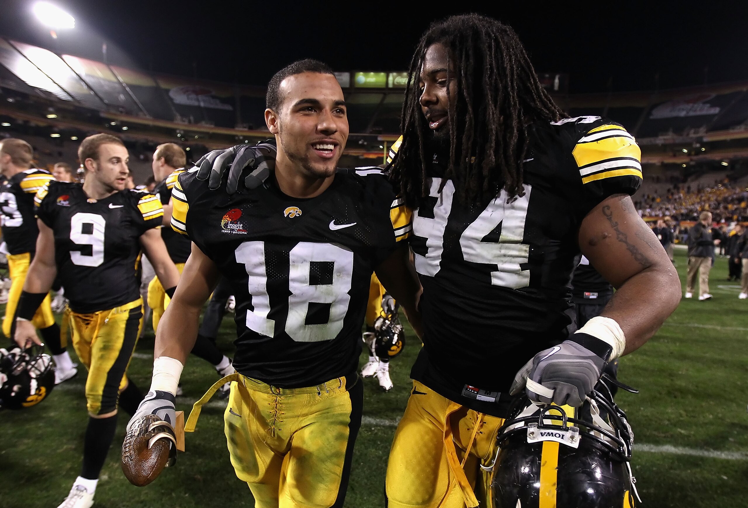 TEMPE, AZ - DECEMBER 28:  Defensive player of the game Micah Hyde #18 and Adrian Clayborn #94 of the Iowa Hawkeyes walk off the field after defeating the Missouri Tigers in the Insight Bowl at Sun Devil Stadium on December 28, 2010 in Tempe, Arizona. The