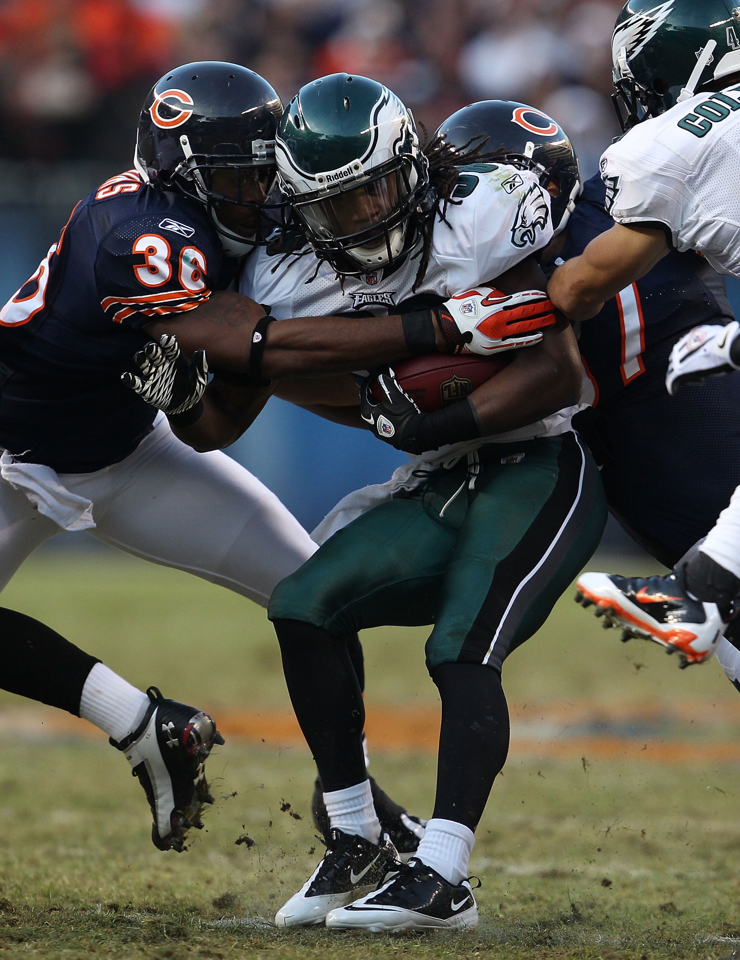 CHICAGO - NOVEMBER 28: Jorrick Calvin #38 of the Philadelphia Eagles is tackled by D.J. Moore #30 and Kellen Davis #87 of the Chicago Bears at Soldier Field on November 28, 2010 in Chicago, Illinois. The Bears defeated the Eagles 31-26. (Photo by Jonathan