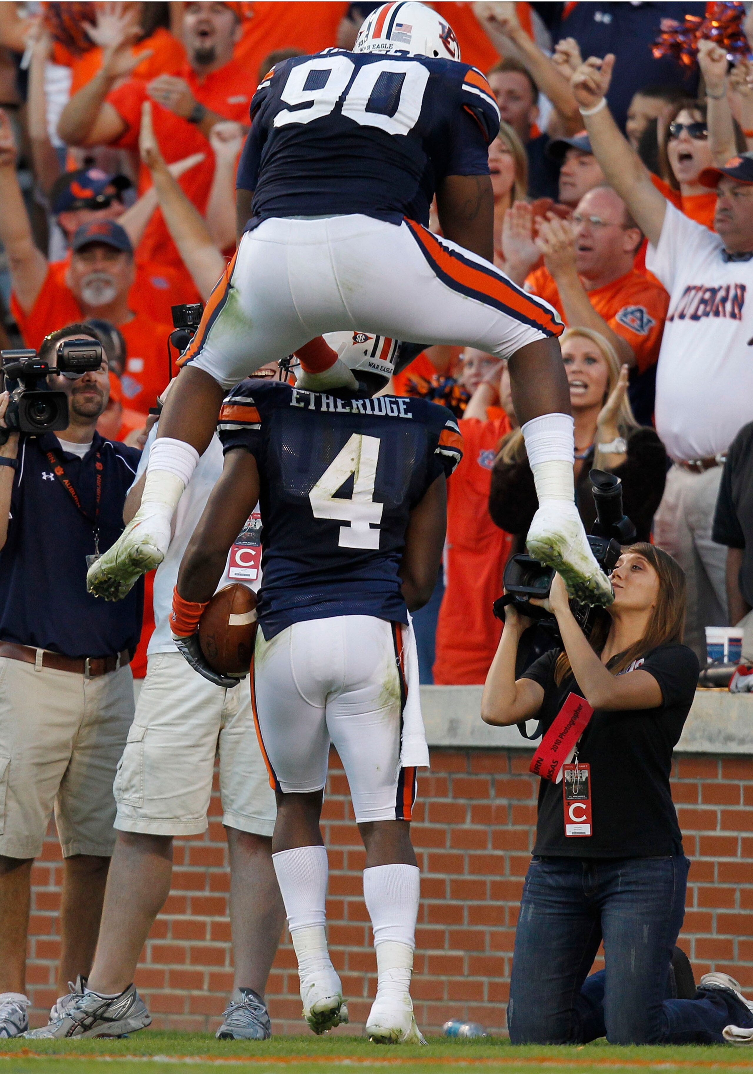 AUBURN - OCTOBER 16:  Defensive lineman Nick Fairley #90 of the Auburn Tigers jumps on the back of teammate and safety Zac Etheridge #4 after Etheridge's fumble return for a touchdown during the game against the Arkansas Razorbacks at Jordan-Hare Stadium