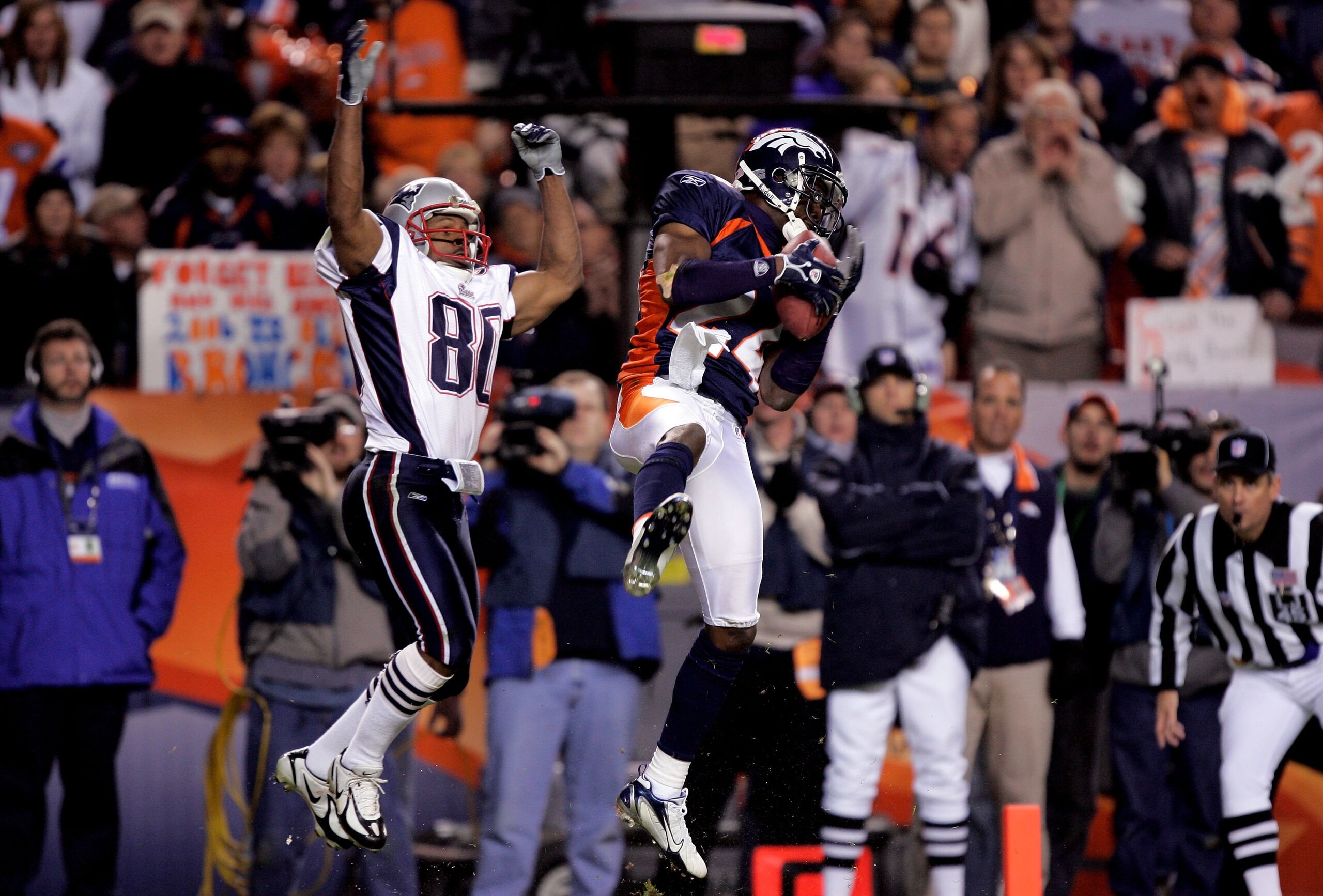 DENVER - JANUARY 14: Cornerback Champ Bailey #24 of the Denver Broncos intercepts a pass in front of wide receiver Troy Brown #80 of the New England Patriots and returns it 100-yards before fumbling at the 1-yard yardline in the third quarter of the AFC DENVER - JANUARY 14: Cornerback Champ Bailey #24 of the Denver Broncos intercepts a pass in front of wide receiver Troy Brown #80 of the New England Patriots and returns it 100-yards before fumbling at the 1-yard yardline in the third quarter of the AFC