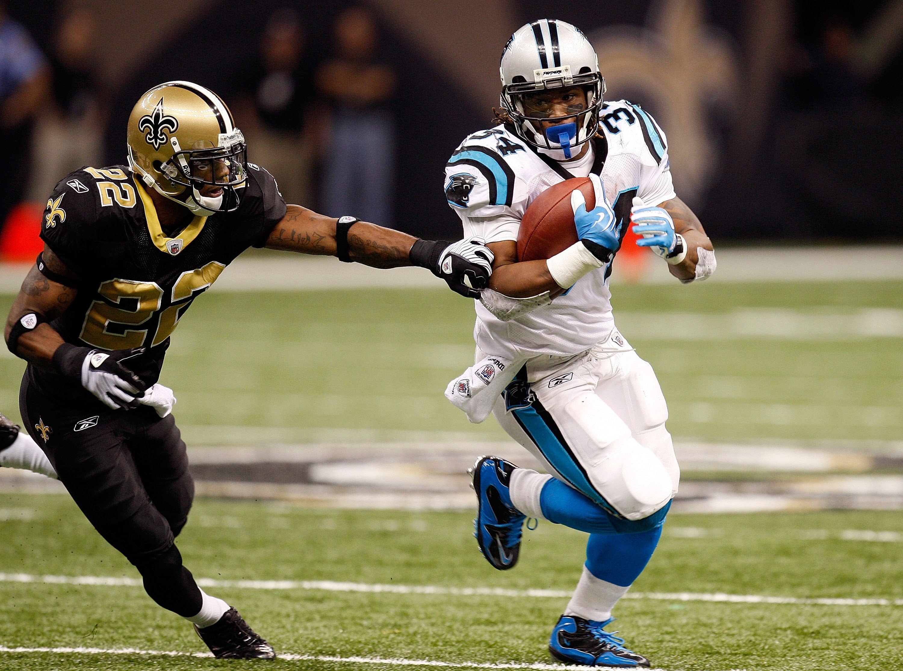 NEW ORLEANS - NOVEMBER 08:  Running back DeAngelo Williams #34 of the Carolina Panthers runs  the ball against Tracy Porter #22 of the New Orleans Saints at Louisiana Superdome on November 8, 2009 in New Orleans, Louisiana.  (Photo by Ronald Martinez/Gett