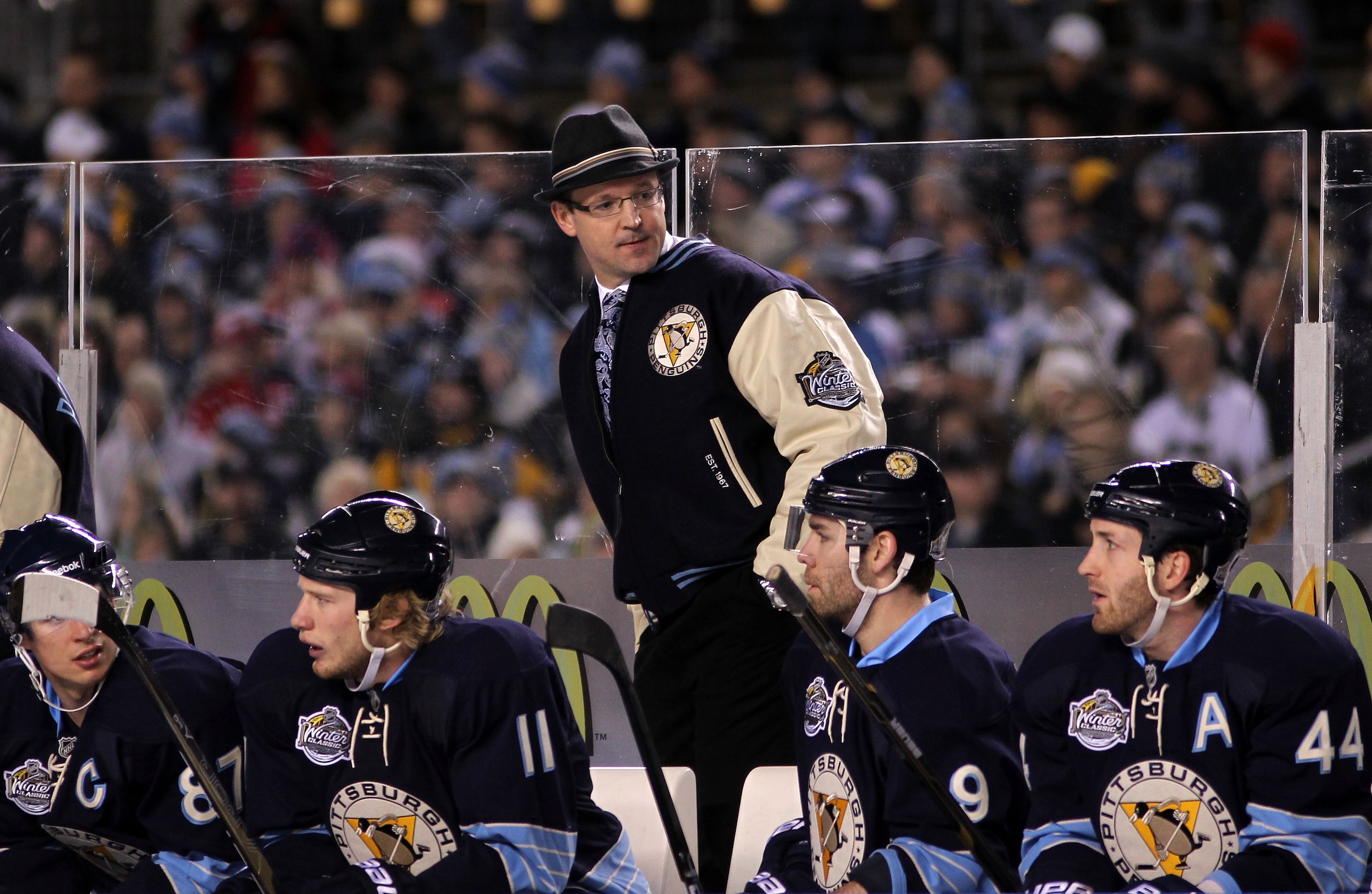 PITTSBURGH, PA - JANUARY 01:  Head coach Dan Bylsma talks with players on the bench during the 2011 NHL Bridgestone Winter Classic against the Washington Capitals at Heinz Field on January 1, 2011 in Pittsburgh, Pennsylvania.  (Photo by Jamie Squire/Getty
