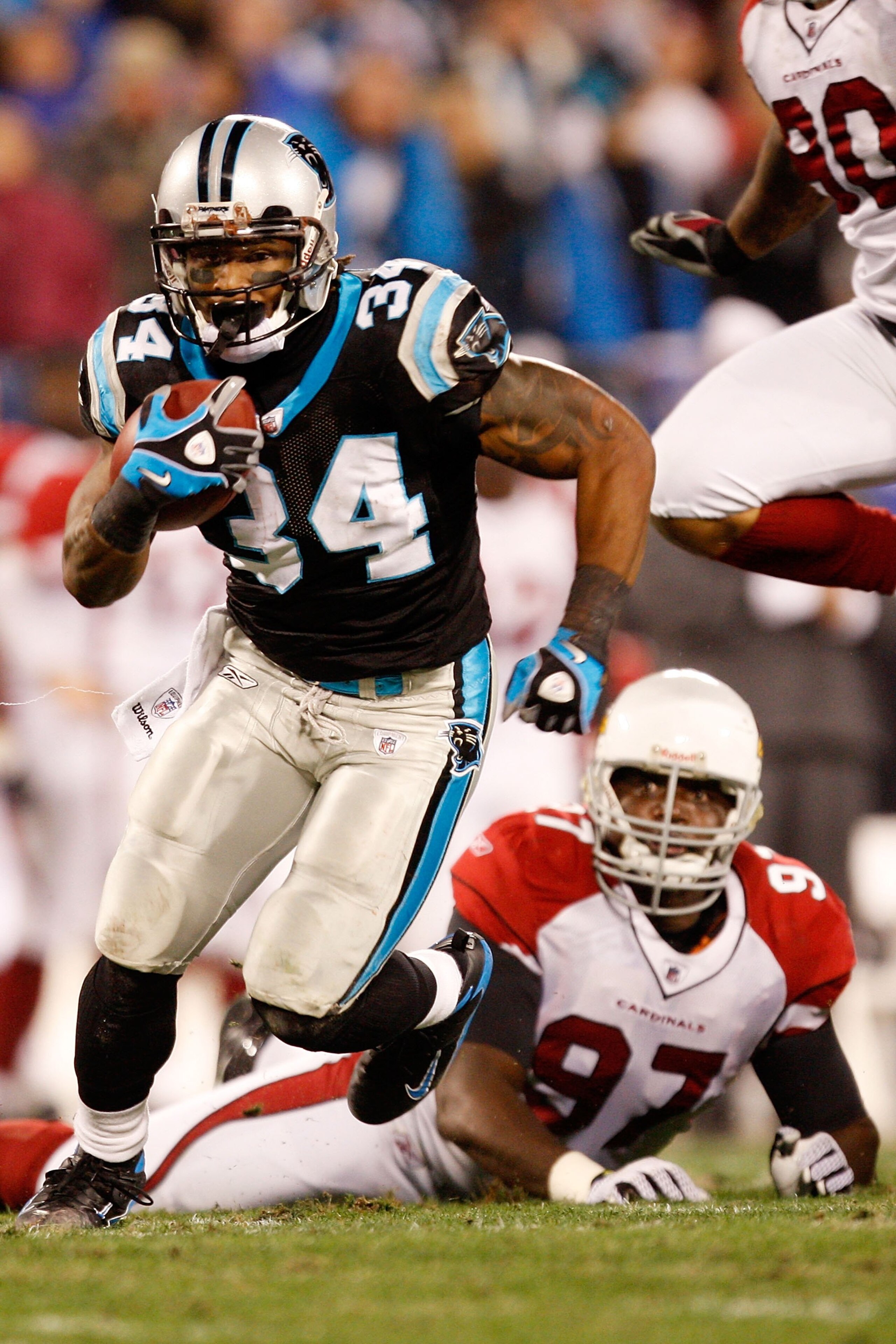 CHARLOTTE, NC - JANUARY 10: DeAngelo Williams #34 of the Carolina Panthers runs the ball while Bryan Robinson #97 of the Arizona Cardinals looks on during the NFC Divisional Playoff Game on January 10, 2009 at Bank of America Stadium in Charlotte, North CHARLOTTE, NC - JANUARY 10: DeAngelo Williams #34 of the Carolina Panthers runs the ball while Bryan Robinson #97 of the Arizona Cardinals looks on during the NFC Divisional Playoff Game on January 10, 2009 at Bank of America Stadium in Charlotte, North