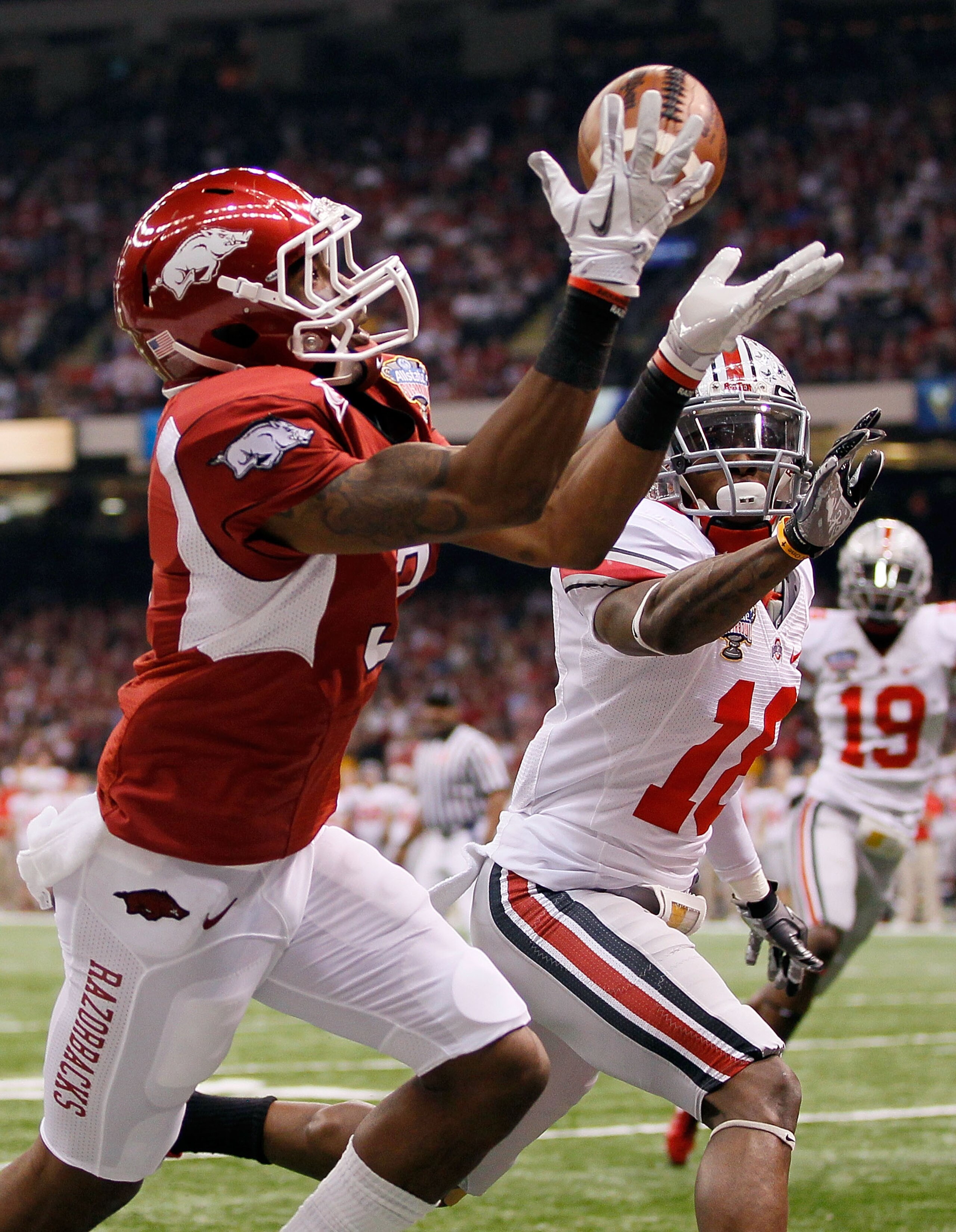 NEW ORLEANS, LA - JANUARY 04:  Joe Adams #3 of the Arkansas Razorbacks catches a 17-yard touchdown pass in the endzone against Travis Howard #18 of the Ohio State Buckeyes in the first quarter during the Allstate Sugar Bowl at the Louisiana Superdome on J