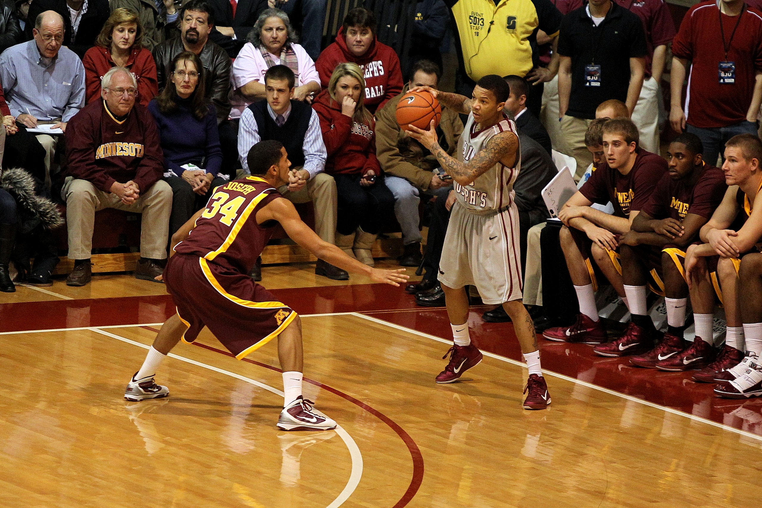 PHILADELPHIA, PA - DECEMBER 08:  Carl Jones #35 of the St. Joseph's Hawks looks to pass the ball against Devoe Joseph #34 of the Minnesota Golden Gophers at Michael J. Hagan Arena on December 8, 2010 in Philadelphia, Pennsylvania.  (Photo by Chris Chamber
