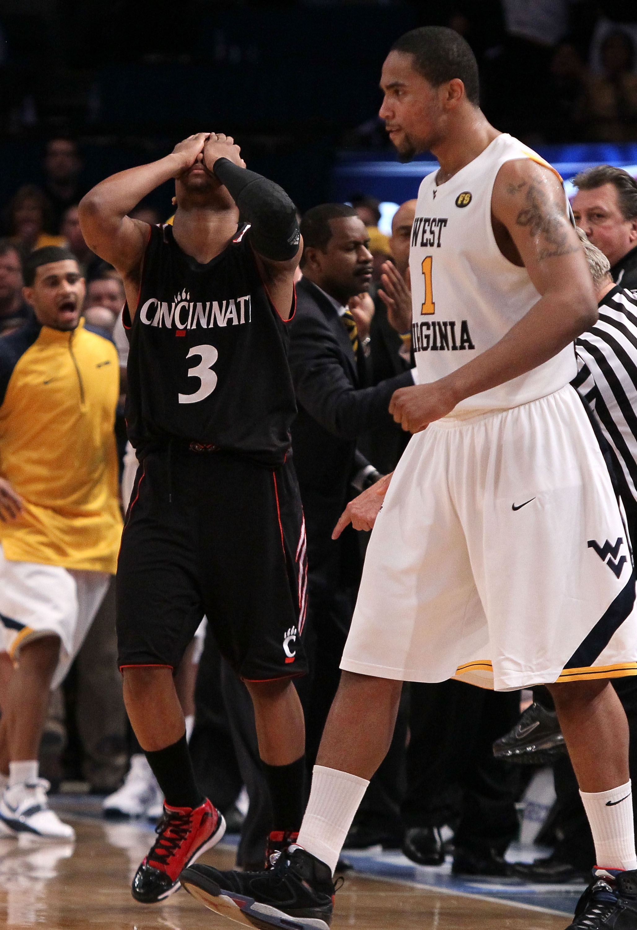 NEW YORK - MARCH 11:  Dion Dixon #3 of the Cincinnati Bearcats reacts late in the game as Da'Sean Butler #1 of the West Virginia Mountaineers looks on during the quarterfinal of the 2010 NCAA Big East Tournament at Madison Square Garden on March 11, 2010 