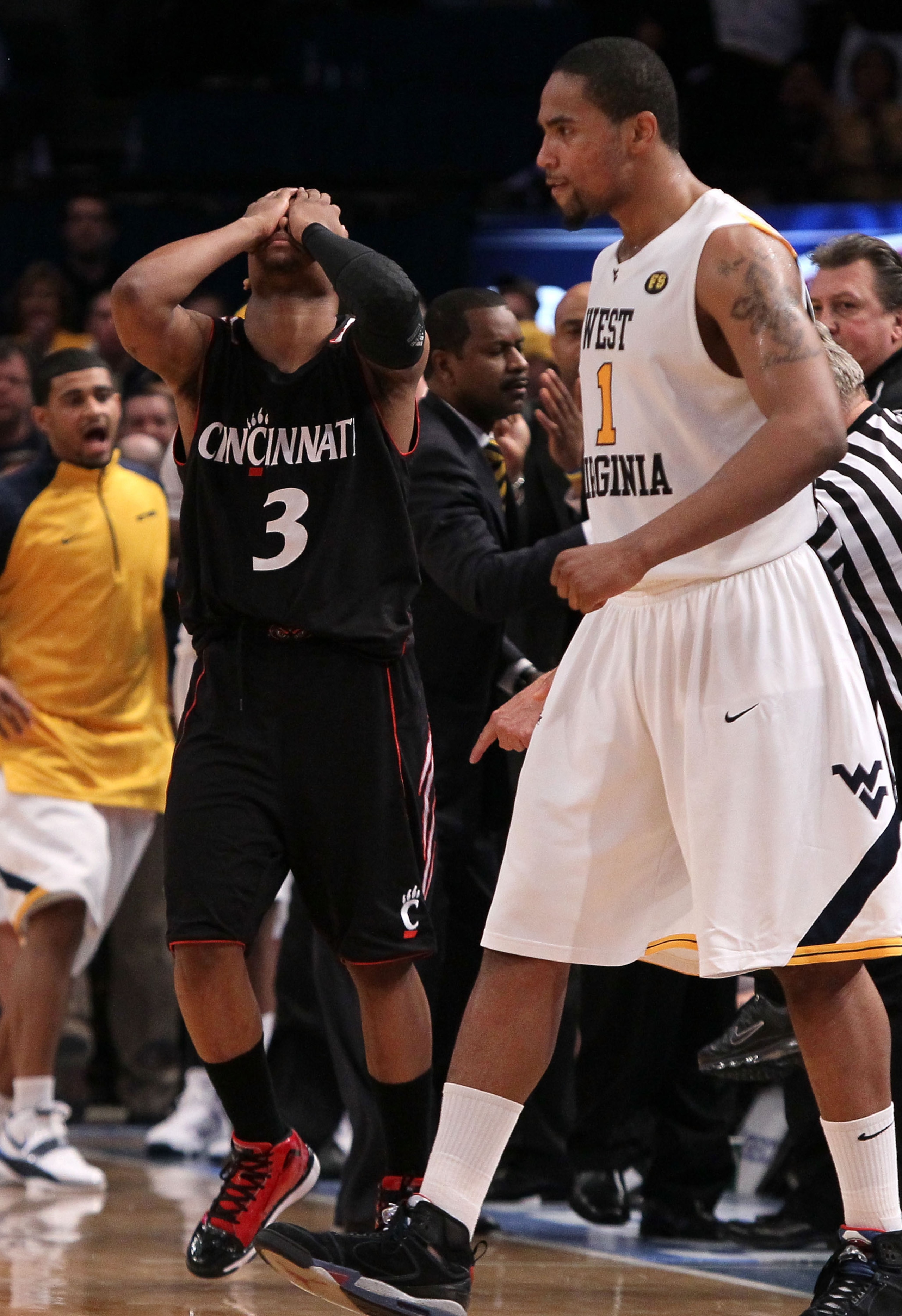 NEW YORK - MARCH 11:  Dion Dixon #3 of the Cincinnati Bearcats reacts late in the game as Da'Sean Butler #1 of the West Virginia Mountaineers looks on during the quarterfinal of the 2010 NCAA Big East Tournament at Madison Square Garden on March 11, 2010 