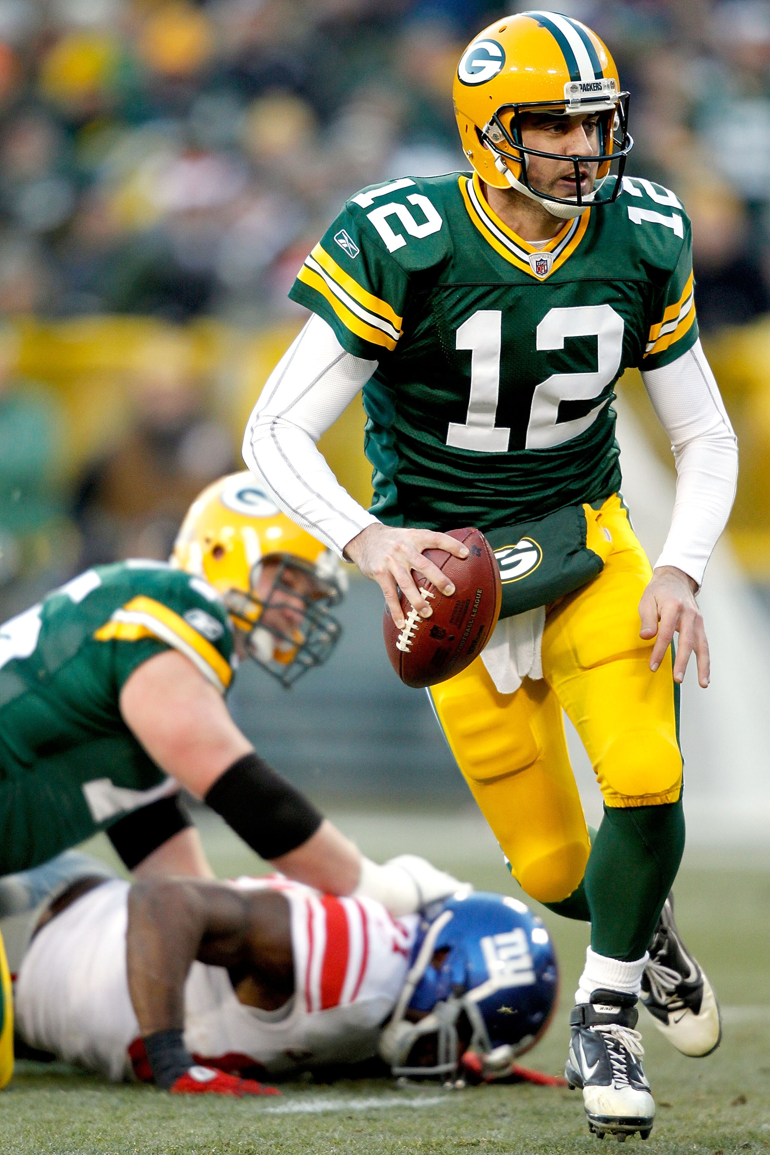 GREEN BAY, WI - DECEMBER 26:  Aaron Rodgers #12 of the Green Bay Packers is chased out of the pocket against the New York Giants at Lambeau Field on December 26, 2010 in Green Bay, Wisconsin.  (Photo by Matthew Stockman/Getty Images)