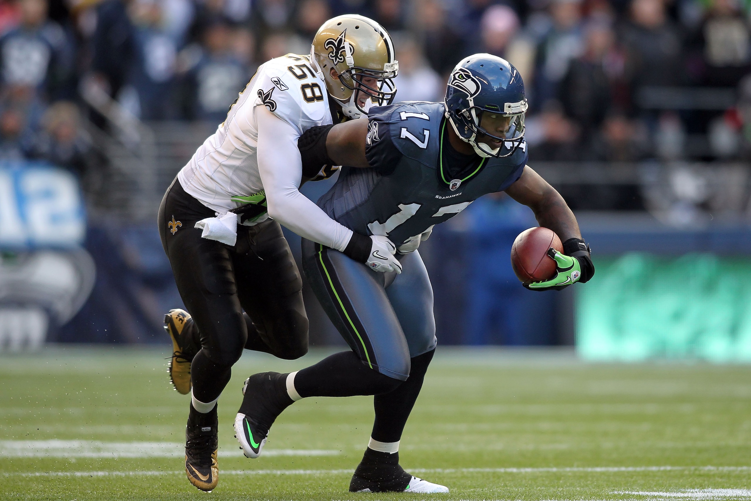 SEATTLE, WA - JANUARY 08:  Mike Williams #17 of the Seattle Seahawks runs after a catch as Scott Shanle #58 of the New Orleans Saints attempts the tackle in the first half during the 2011 NFC wild-card playoff game at Qwest Field on January 8, 2011 in Sea