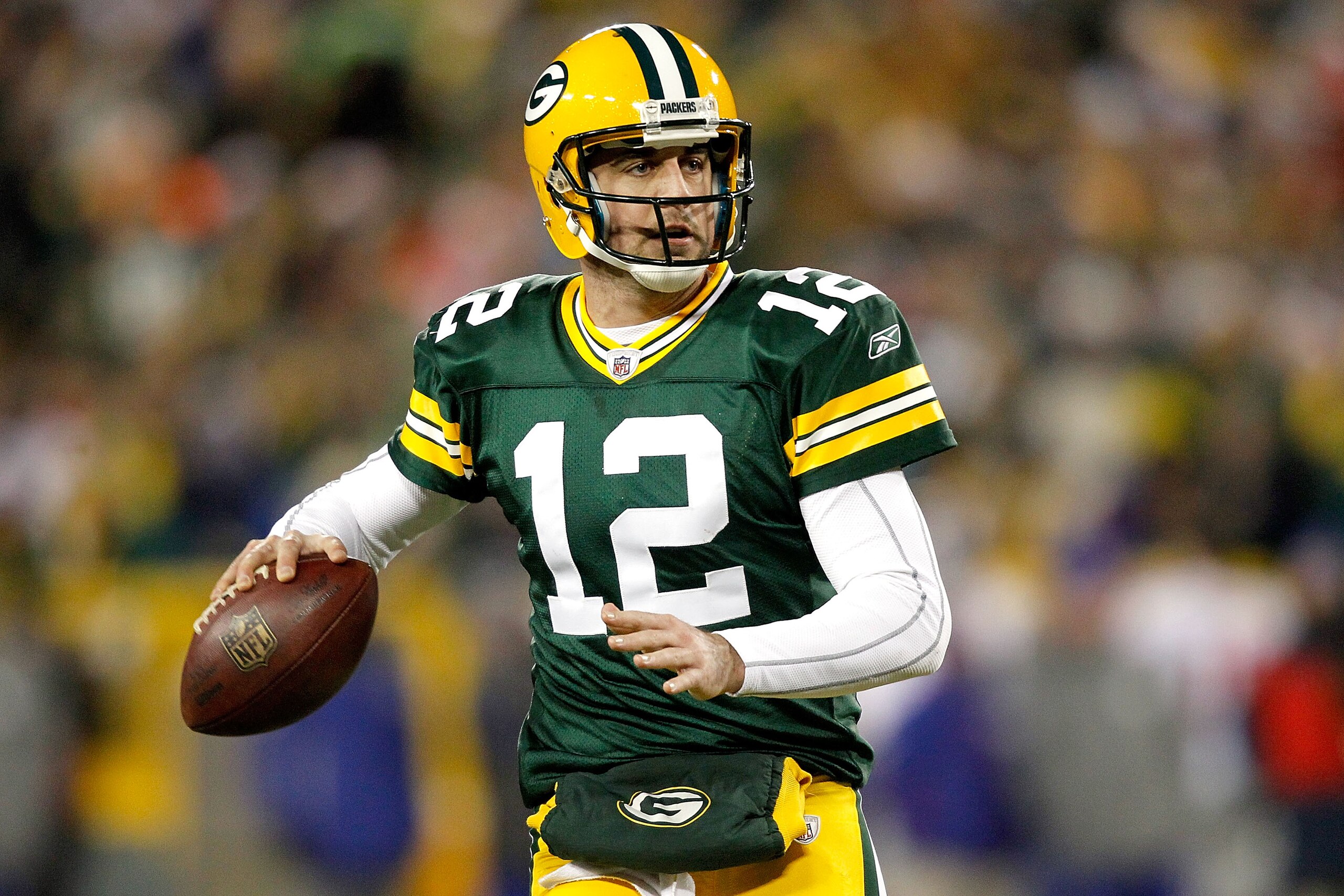 GREEN BAY, WI - DECEMBER 26:  Aaron Rodgers #12 of the Green Bay Packers rolls out of the pocket against the New York Giants at Lambeau Field on December 26, 2010 in Green Bay, Wisconsin.  (Photo by Matthew Stockman/Getty Images)