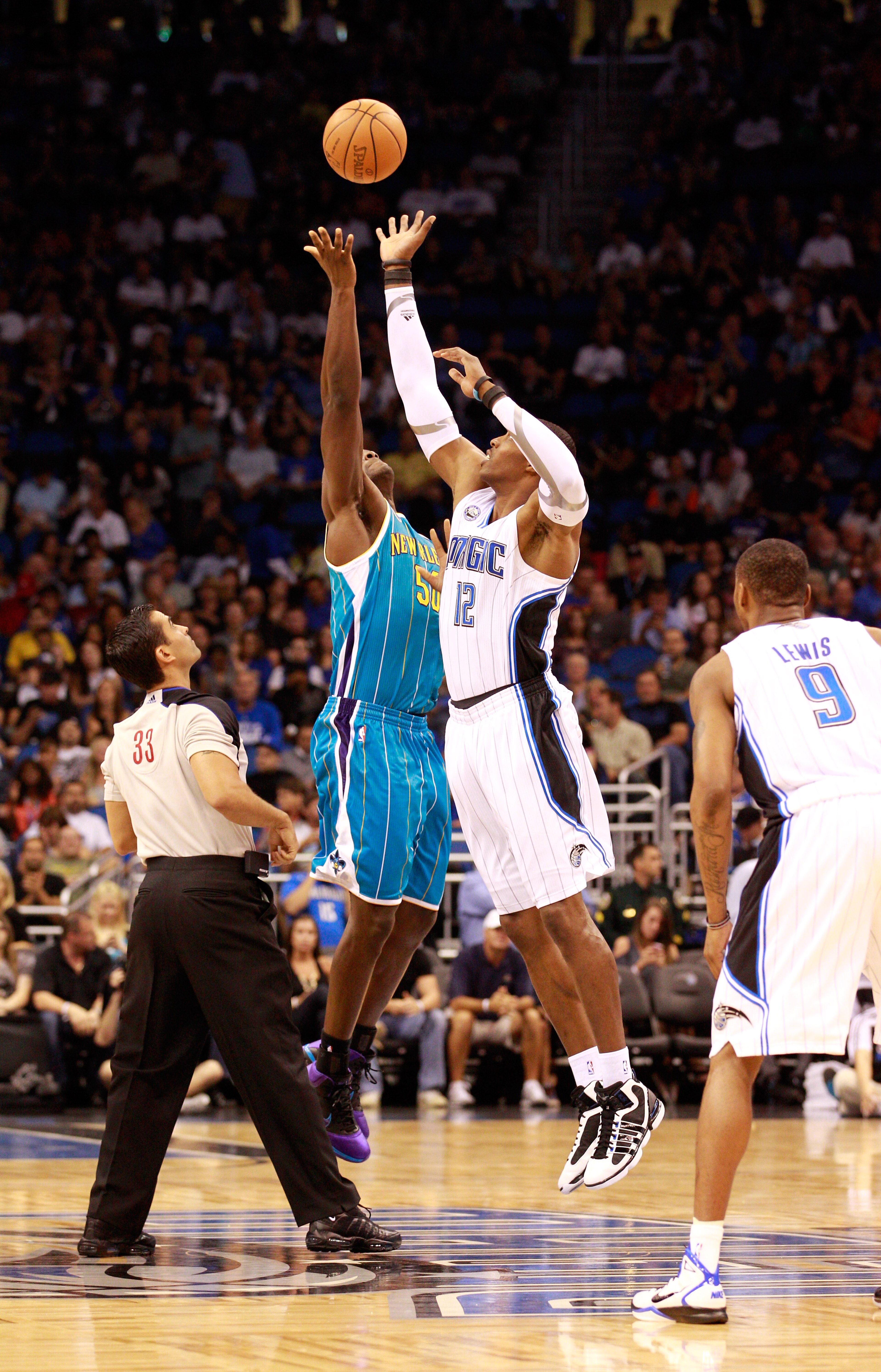 ORLANDO, FL - OCTOBER 10:  Dwight Howard #12 of the Orlando Magic jumps against  Emeka Okafor #50 of the New Orleans Hornets during the game at Amway Arena on October 10, 2010 in Orlando, Florida. NOTE TO USER: User expressly acknowledges and agrees that,