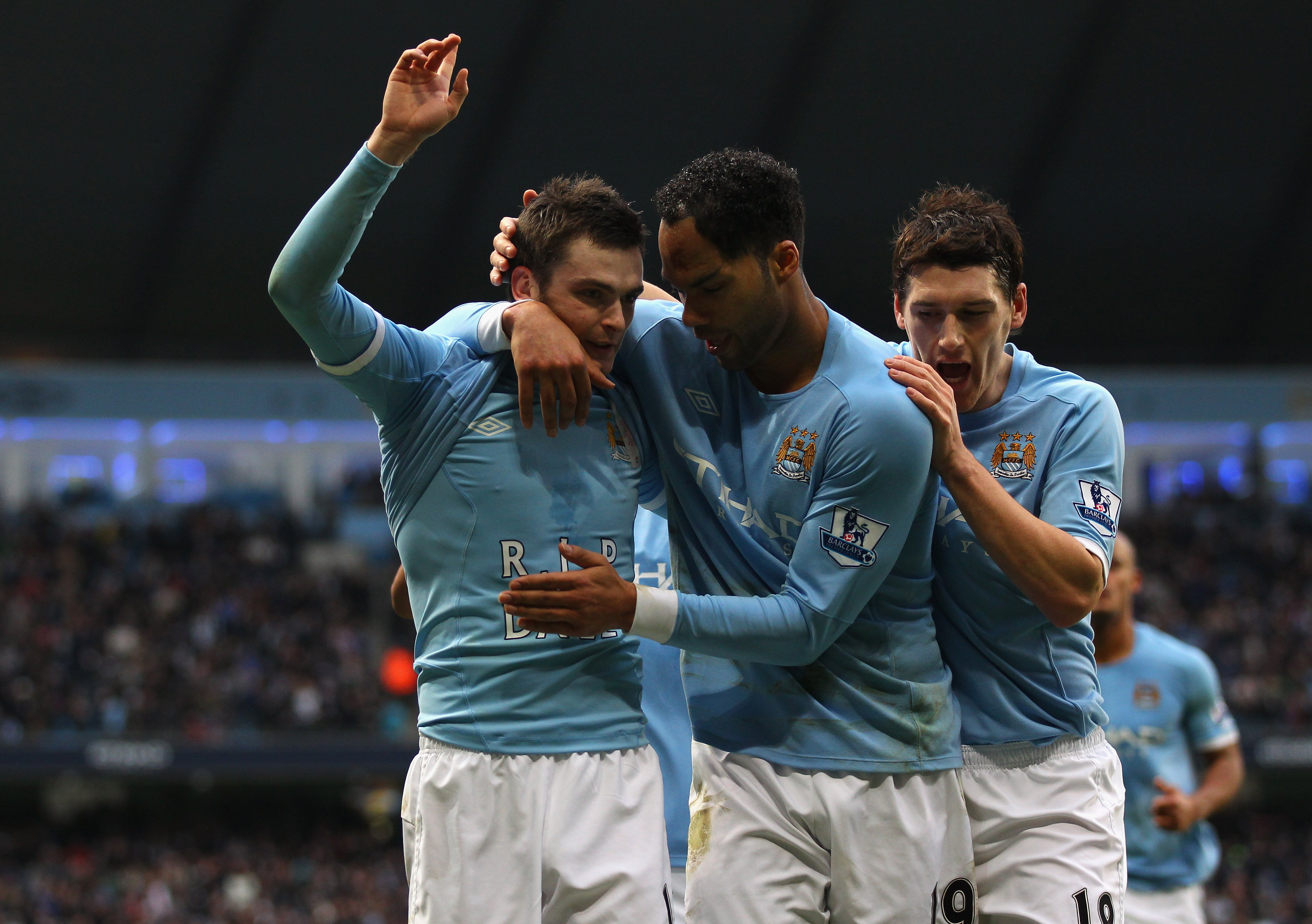 MANCHESTER, ENGLAND - JANUARY 01:  Adam Johnson of Manchester City celebrates with Joleon Lescott and Gareth Barry after scoring the opening goal during the Barclays Premier League match between Manchester City and Blackpool at the City of Manchester Stad