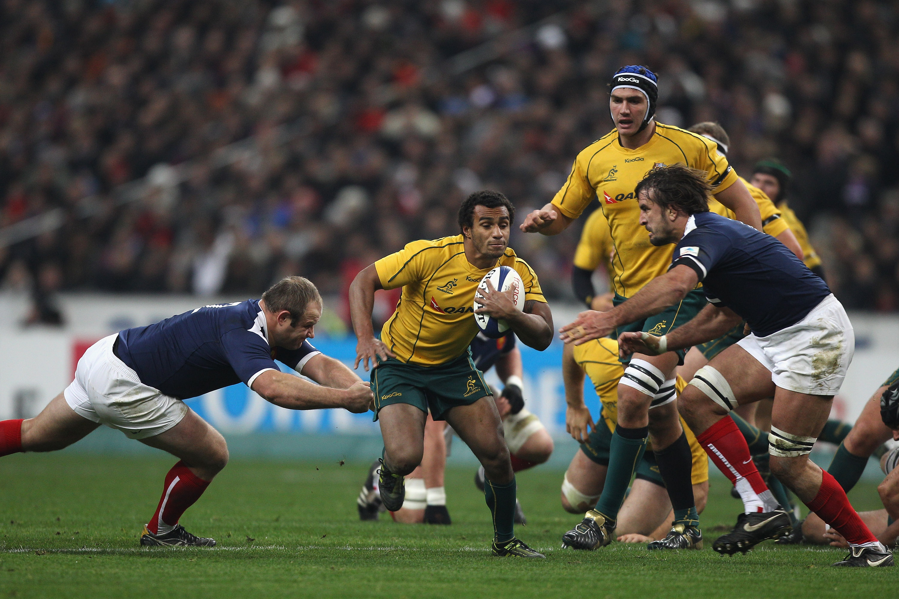 PARIS - NOVEMBER 27: Will Genia (c) of Australia cuts between Julien Pierre (r) and William Servat (l) during the Test match between France and the Australian Wallabies at the Stade de France on November 27, 2010 in Paris. (Photo by Michael Steele/Getty