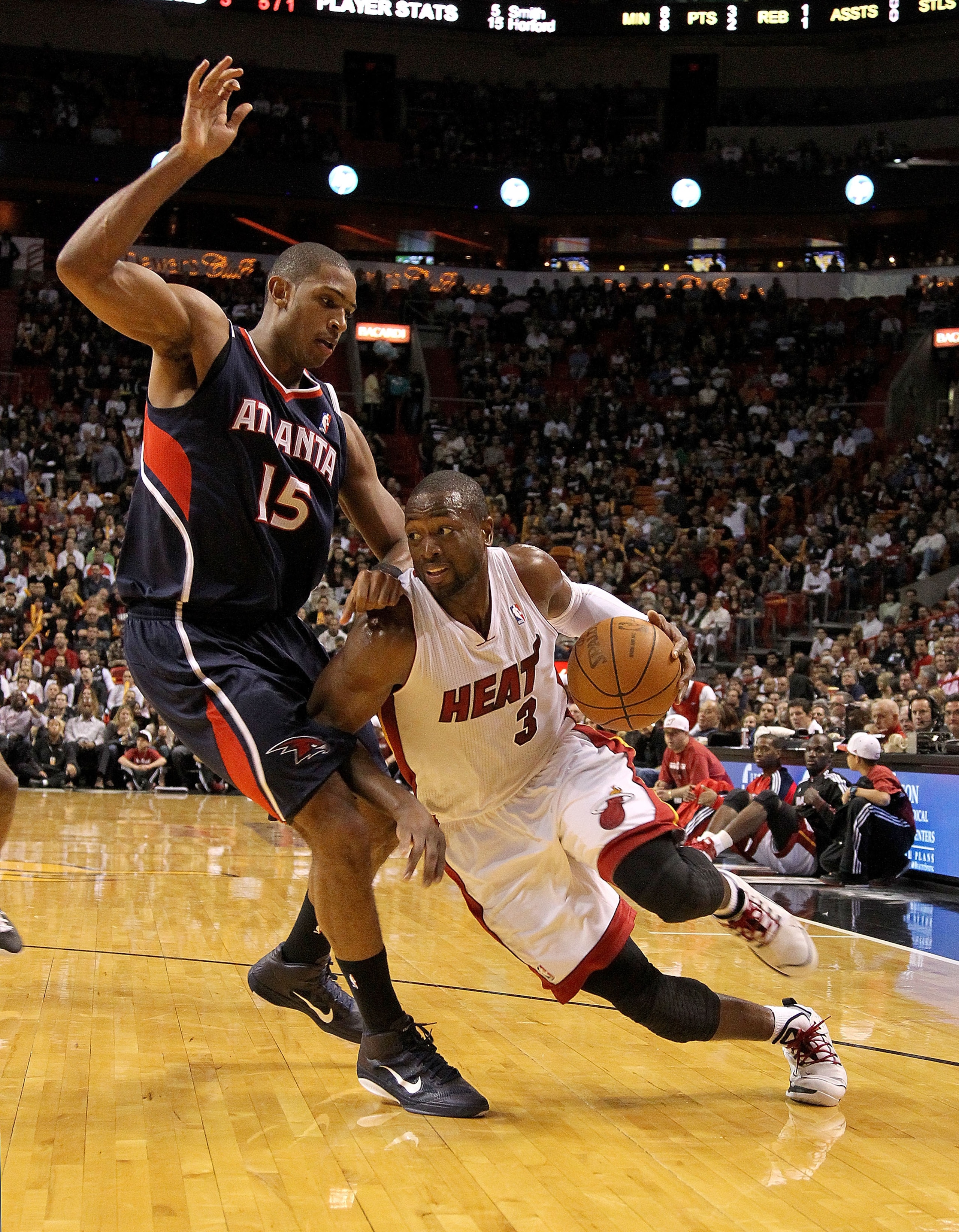 MIAMI, FL - DECEMBER 04:  Dwyane Wade #3 of the Miami Heat dribbles around Al Horford #15 of the Atlanta Hawks during a game at American Airlines Arena on December 4, 2010 in Miami, Florida. NOTE TO USER: User expressly acknowledges and agrees that, by do