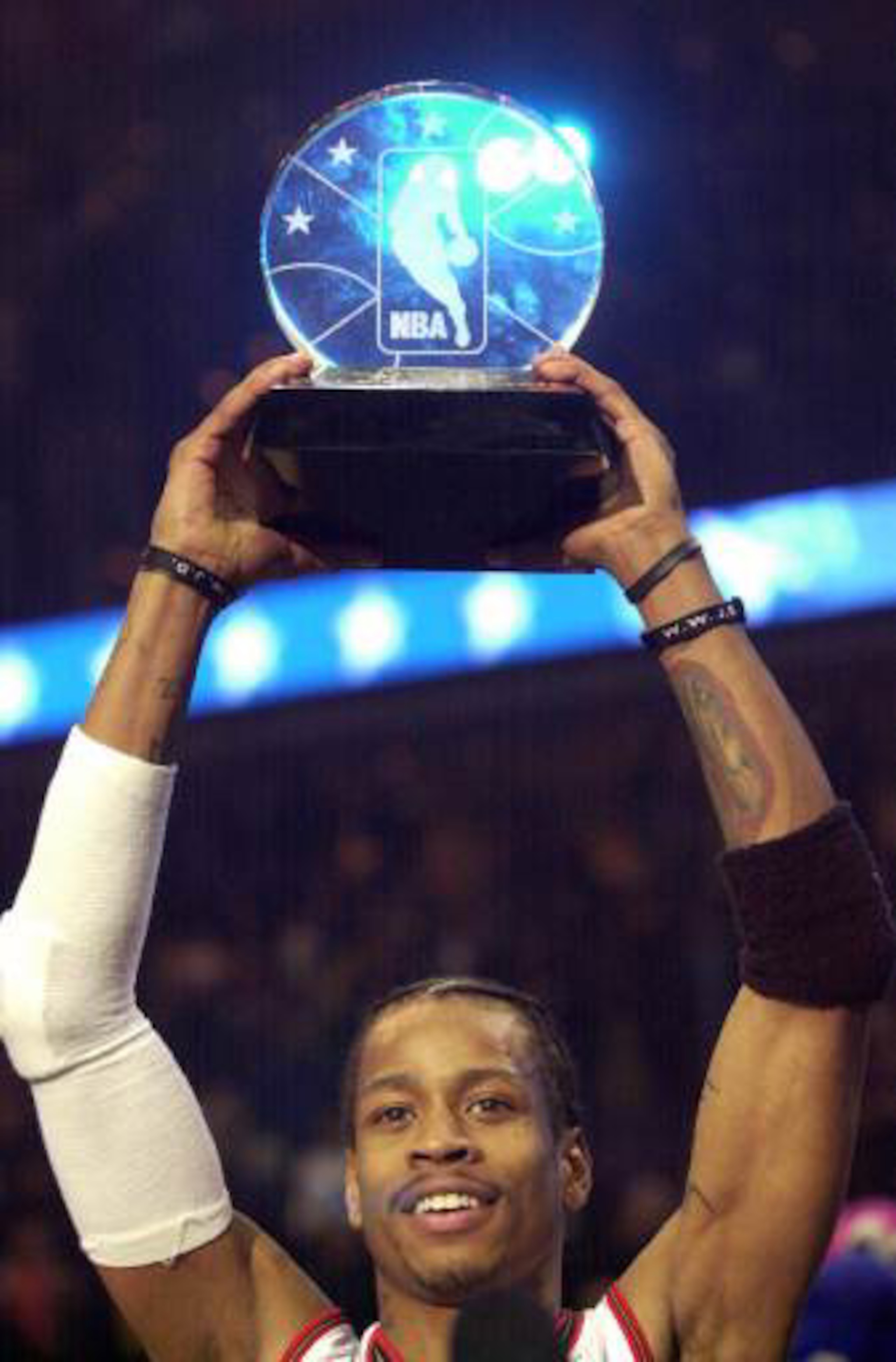 Basketball player Allen Iverson, #3 of the Philadelphia 76ers and the Eastern Conference All-Stars, holds aloft his MVP trophy following the NBA All-Star Game at the MCI Center in Washington, D.C., February 11, 2000. (Photo M. David Leeds/Allsport/Getty I