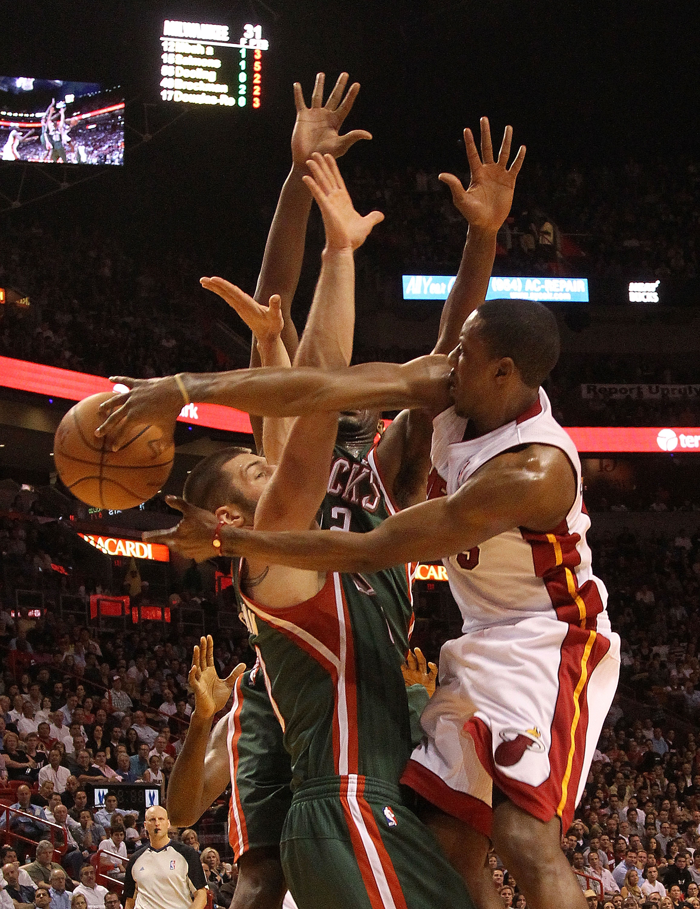 MIAMI, FL - JANUARY 04: Mario Chalmers #15 of the Miami Heat passes the ball over Jon Brockman #40 of the Milwaukee Bucks during a game at American Airlines Arena on January 4, 2011 in Miami, Florida. NOTE TO USER: User expressly acknowledges and agrees t MIAMI, FL - JANUARY 04: Mario Chalmers #15 of the Miami Heat passes the ball over Jon Brockman #40 of the Milwaukee Bucks during a game at American Airlines Arena on January 4, 2011 in Miami, Florida. NOTE TO USER: User expressly acknowledges and agrees t