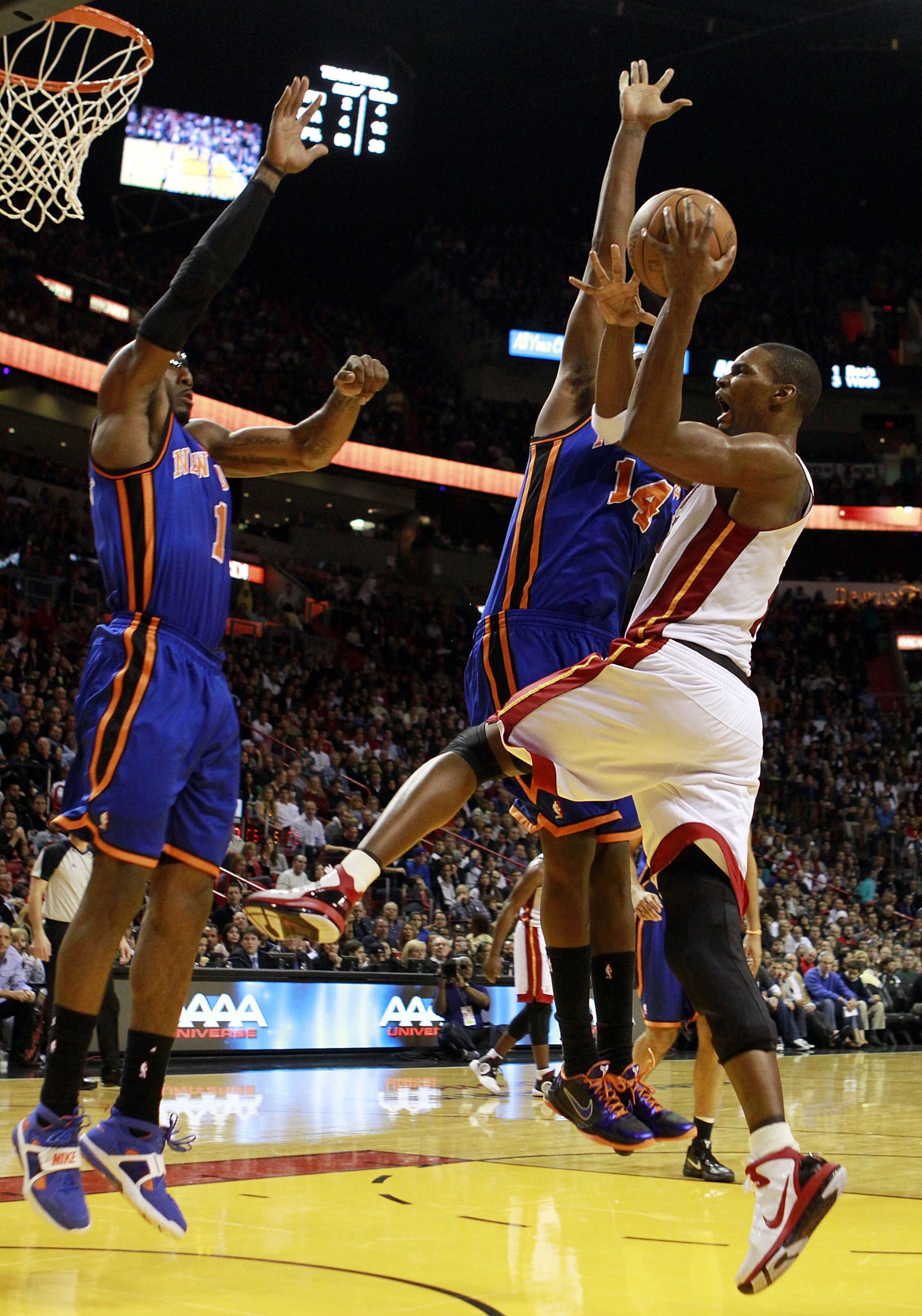 MIAMI - DECEMBER 28: Forward Chris Bosh #1 of the Miami Heat is fouled by Forward Amar'e Stoudemire #1 and Ronnie Turiaf #14 of the New York Knicks game at American Airlines Arena on December 28, 2010 in Miami, Florida.  (Photo by Marc Serota/Getty Images