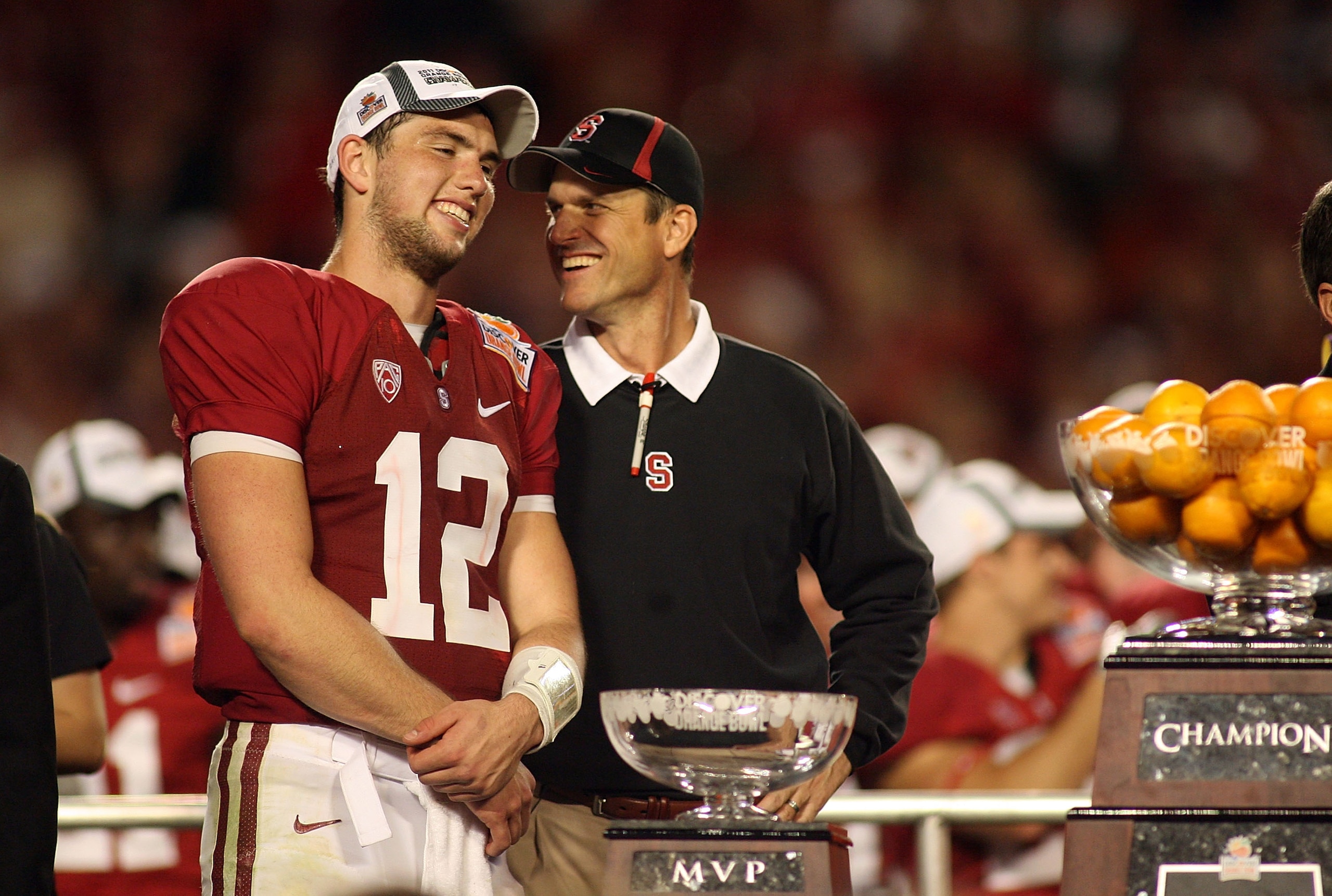 MIAMI, FL - JANUARY 03: (L-R) Quarterback Andrew Luck #12 and head coach Jim Harbaugh of the Stanford Cardinal celebrate with the trophy on stage after Stanford won 40-12 against the Virginia Tech Hokies during the 2011 Discover Orange Bowl at Sun Life St