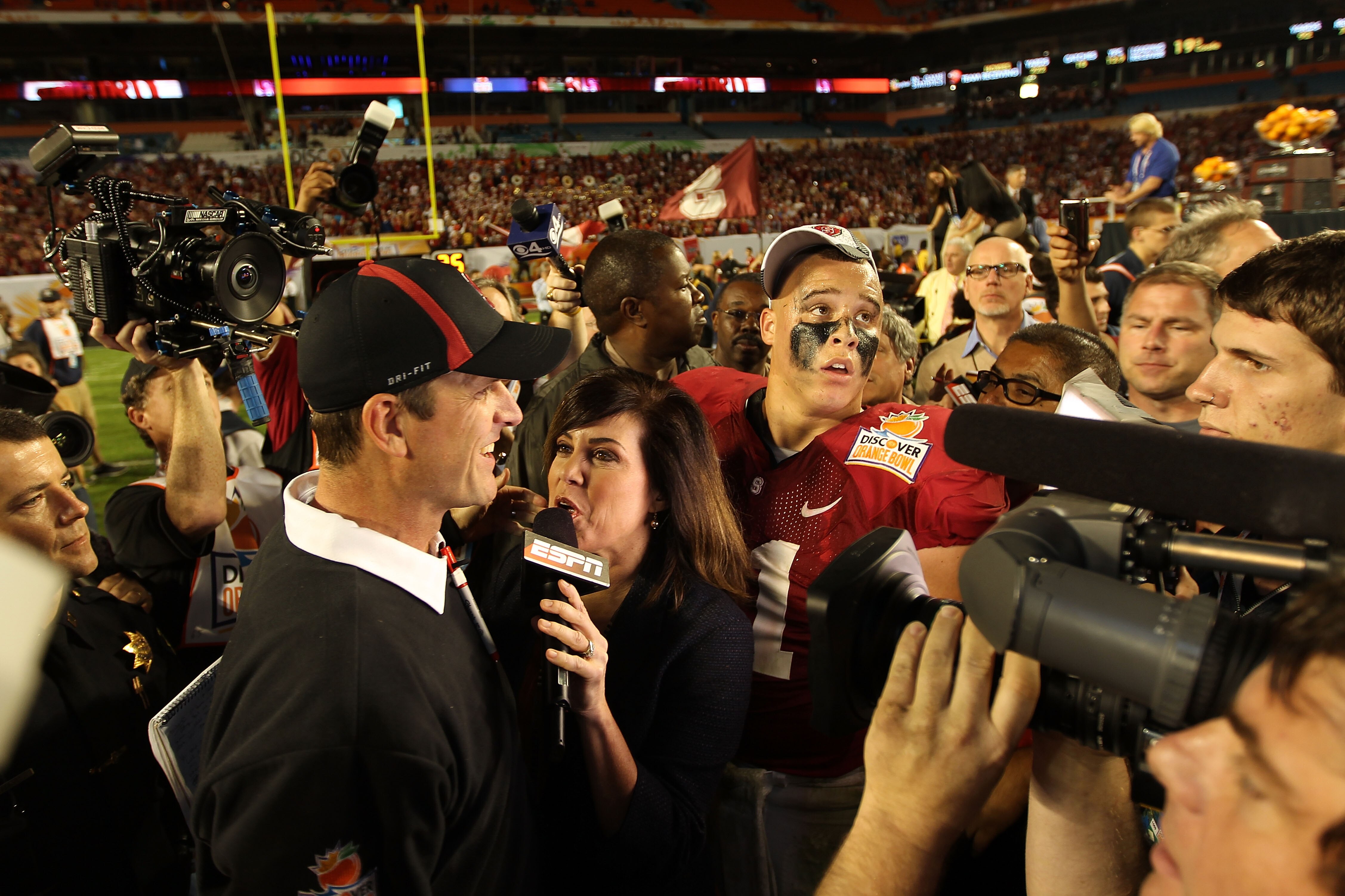 MIAMI, FL - JANUARY 03: Head coach Jim Harbaugh of the Stanford Cardinal is interviewed by ESPN's Michelle Tafoya after Stanford won 40-12 against the Virginia Tech Hokies during the 2011 Discover Orange Bowl at Sun Life Stadium on January 3, 2011 in Miam