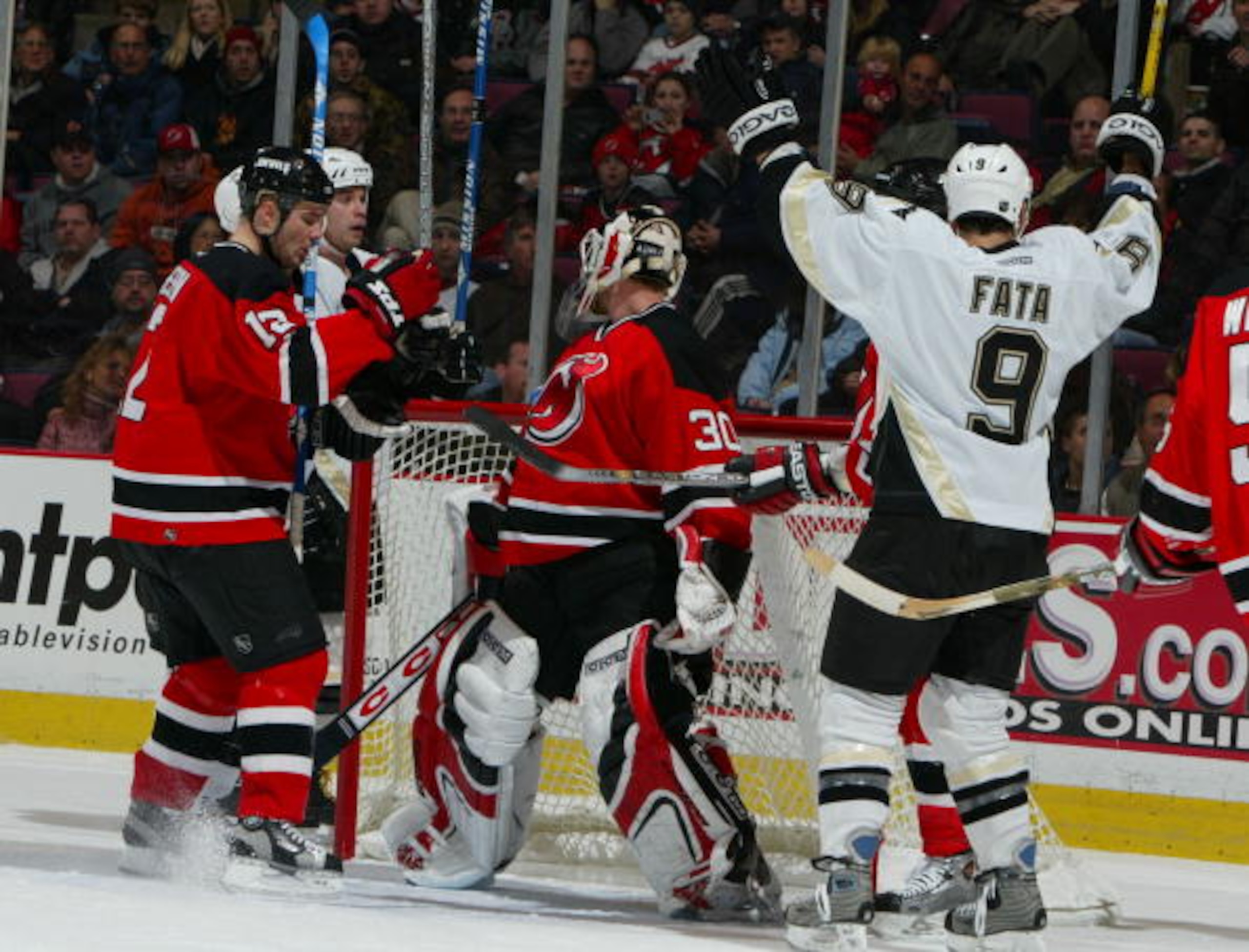 EAST RUTHERFORD, NJ - JANUARY 7:  Martin Brodeur #30 of the New Jersey Devils lets the puck go behind his skate for a goal as Rico Fata #9 of the Pittsburgh Penguins celebrates  during the first period of their game at the Continental Airlines Arena Janua