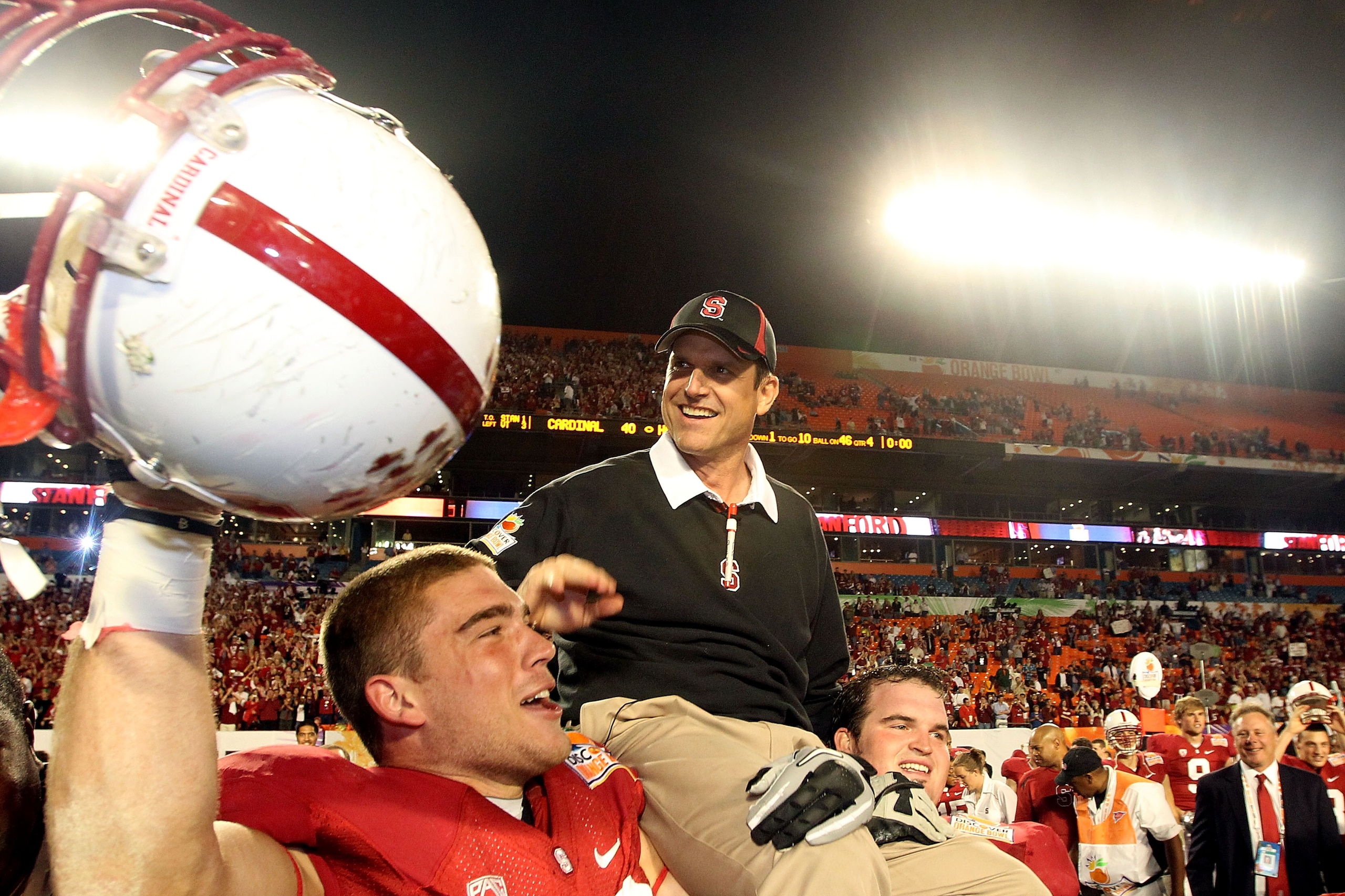 MIAMI, FL - JANUARY 03: Head coach Jim Harbaugh of the Stanford Cardinal celebrates as he is lifted up by his players after Stanford won 40-12 against the Virginia Tech Hokies during the 2011 Discover Orange Bowl at Sun Life Stadium on January 3, 2011 in