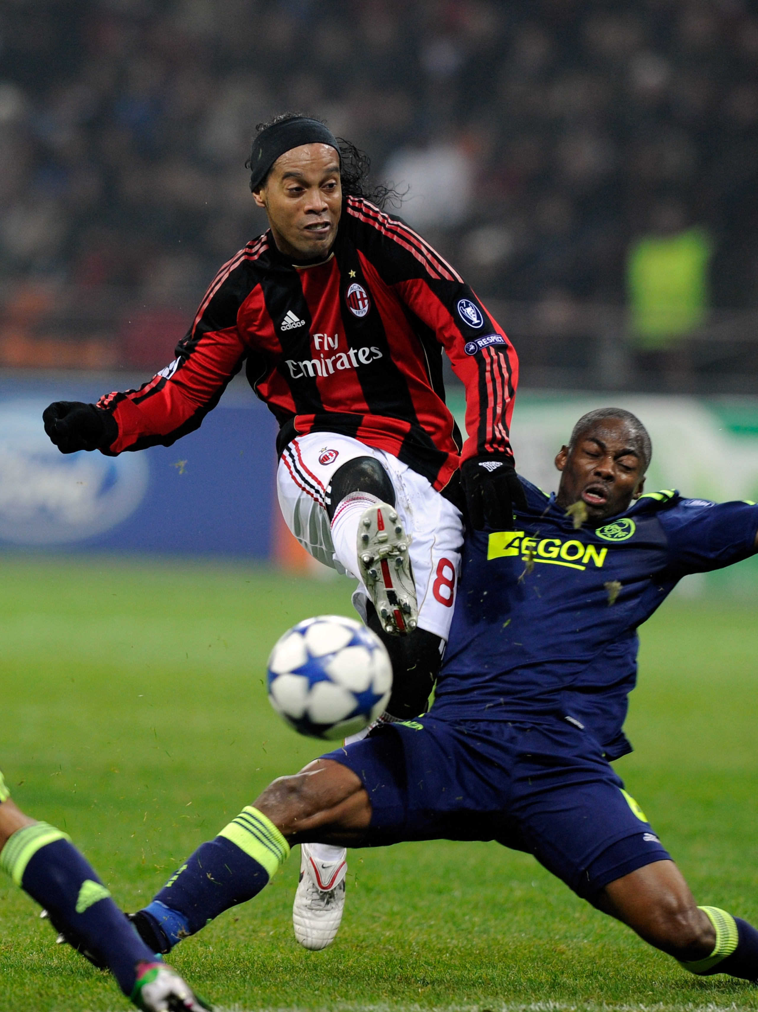 MILAN, ITALY - DECEMBER 08: Ronaldinho of AC Milan and Eyong Enoh of AFC Ajax compete for the ball during the UEFA Champions League Group G match between AC Milan and AFC Ajax at Stadio Giuseppe Meazza on December 8, 2010 in Milan, Italy. (Photo by Clau MILAN, ITALY - DECEMBER 08: Ronaldinho of AC Milan and Eyong Enoh of AFC Ajax compete for the ball during the UEFA Champions League Group G match between AC Milan and AFC Ajax at Stadio Giuseppe Meazza on December 8, 2010 in Milan, Italy. (Photo by Clau