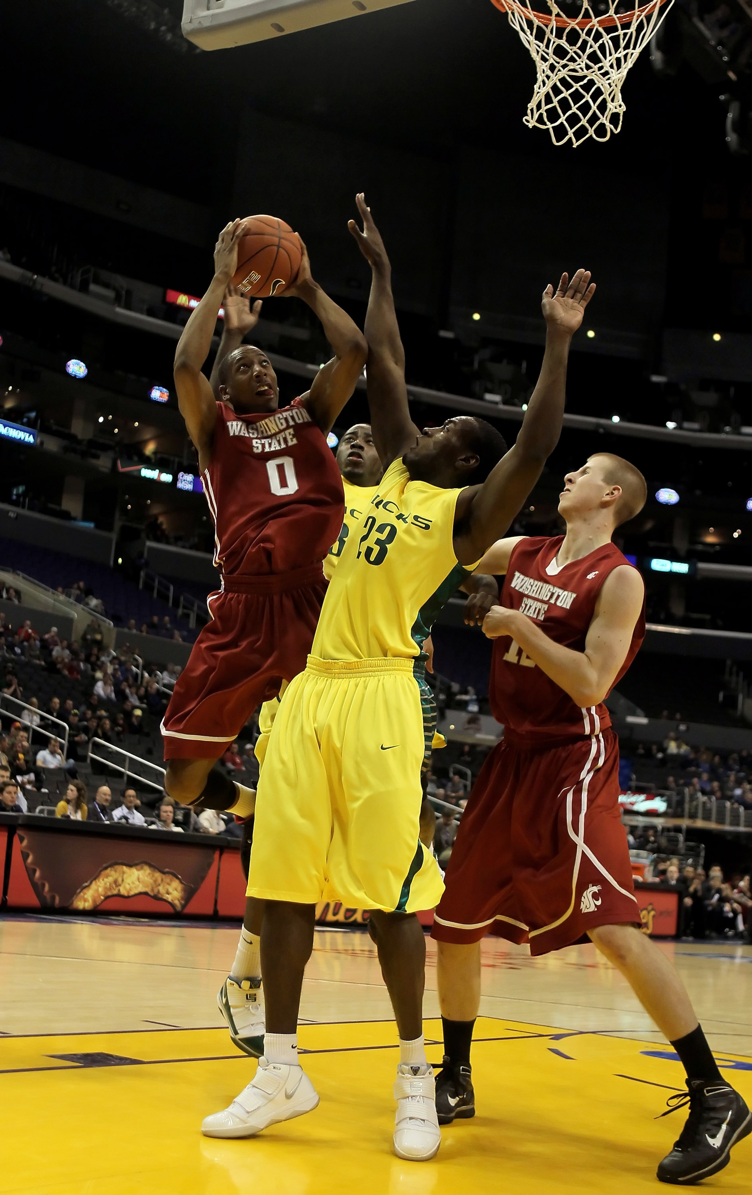LOS ANGELES, CA - MARCH 10:  Marcus Capers #0 of the Washington State Cougars drives to the basket while being defended by DeAngelo Casto #23 of the Oregon Ducks in the half during the first round of the Pac-10 Basketball Tournament at Staples Center on M
