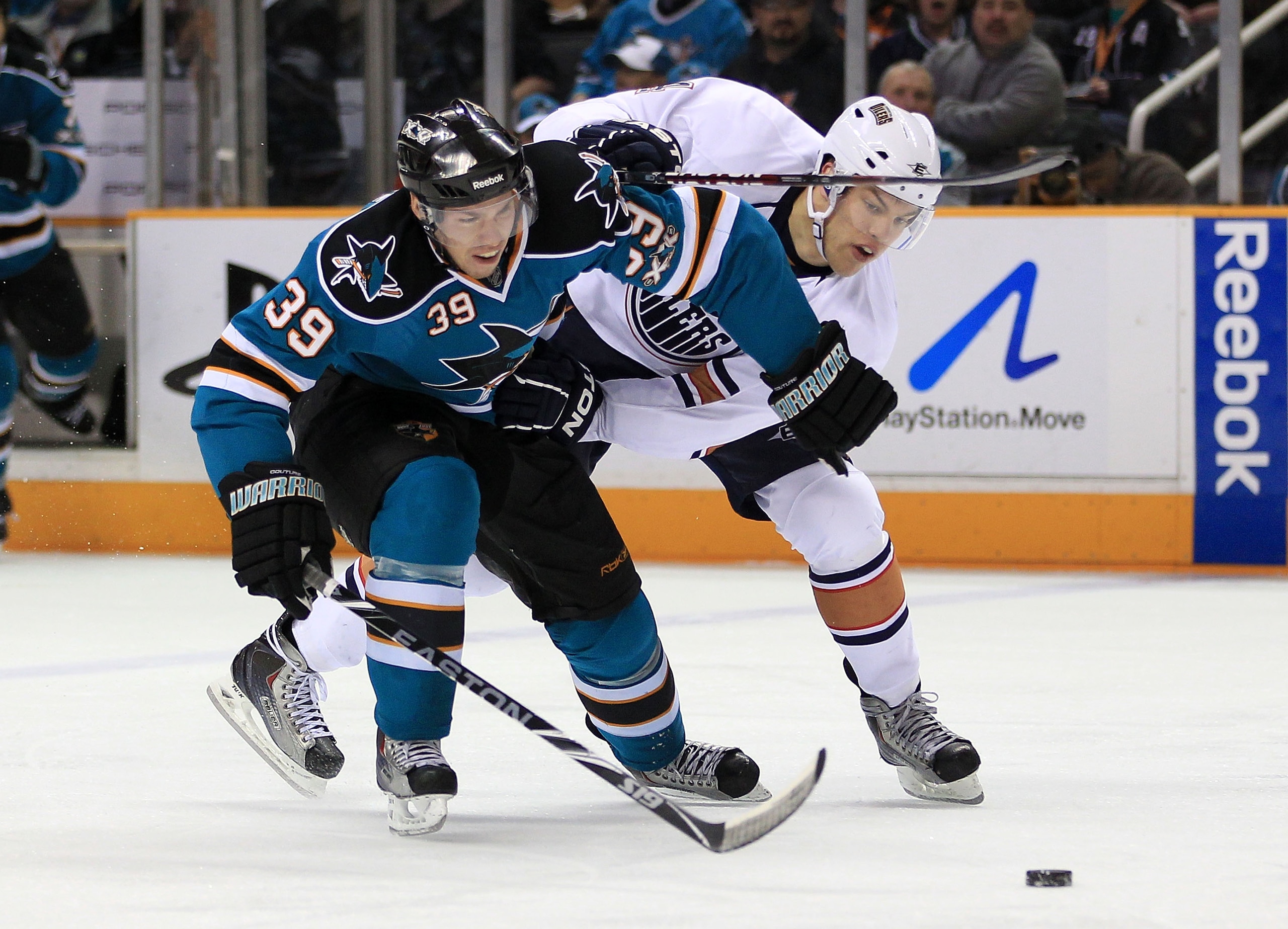 SAN JOSE, CA - DECEMBER 21:  Logan Couture #39 of the San Jose Sharks and  Taylor Hall #4 of the Edmonton Oilers go for the puck at HP Pavilion on December 21, 2010 in San Jose, California.  (Photo by Ezra Shaw/Getty Images)