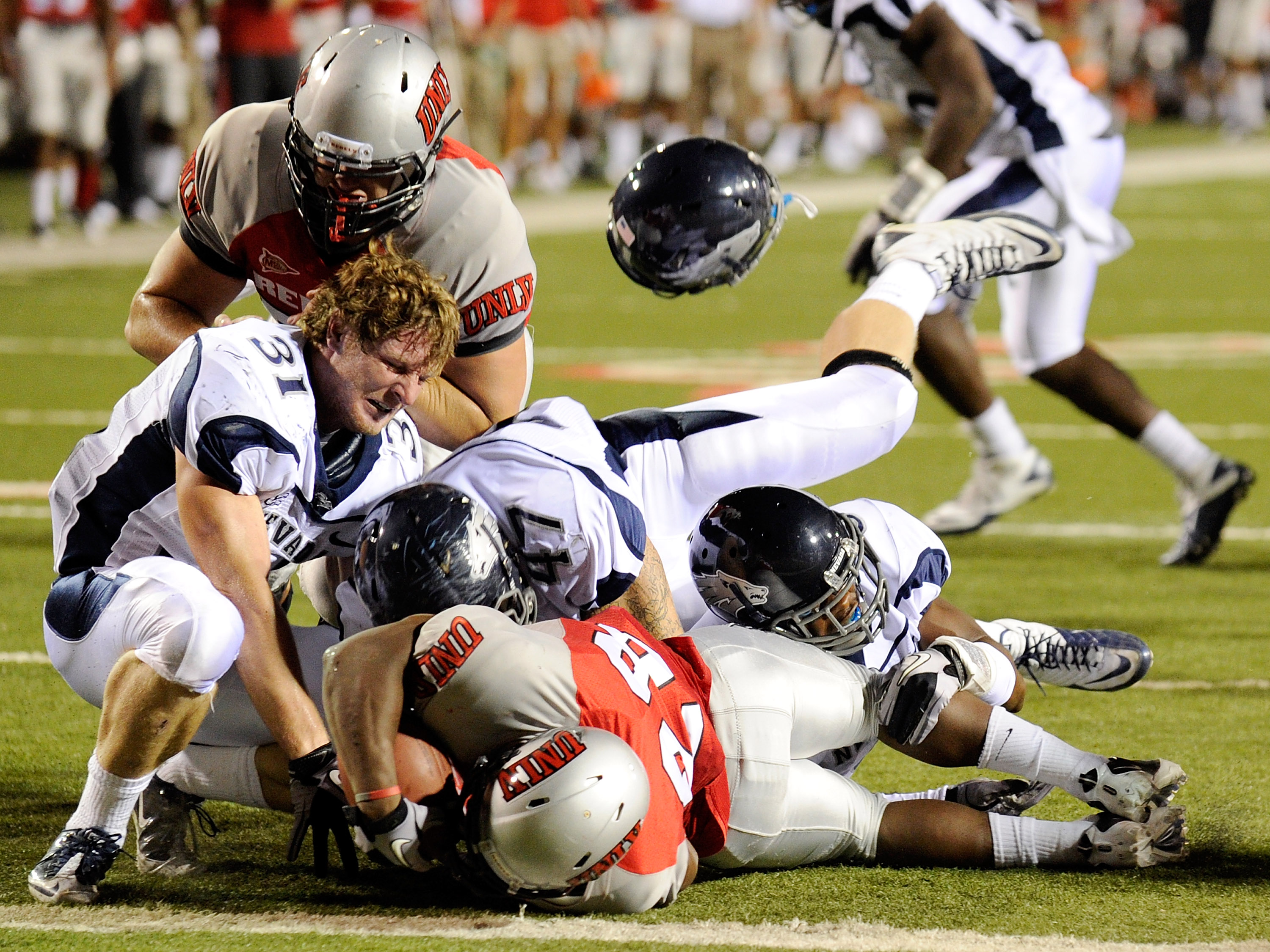 LAS VEGAS - OCTOBER 02: Kevin Grimes #31 of the Nevada Reno Wolf Pack loses his helmet as Wolf Pack defenders tackle Bradley Randle #28 of the UNLV Rebels at Sam Boyd Stadium October 2, 2010 in Las Vegas, Nevada. Nevada Reno won 44-26. (Photo by Ethan M
