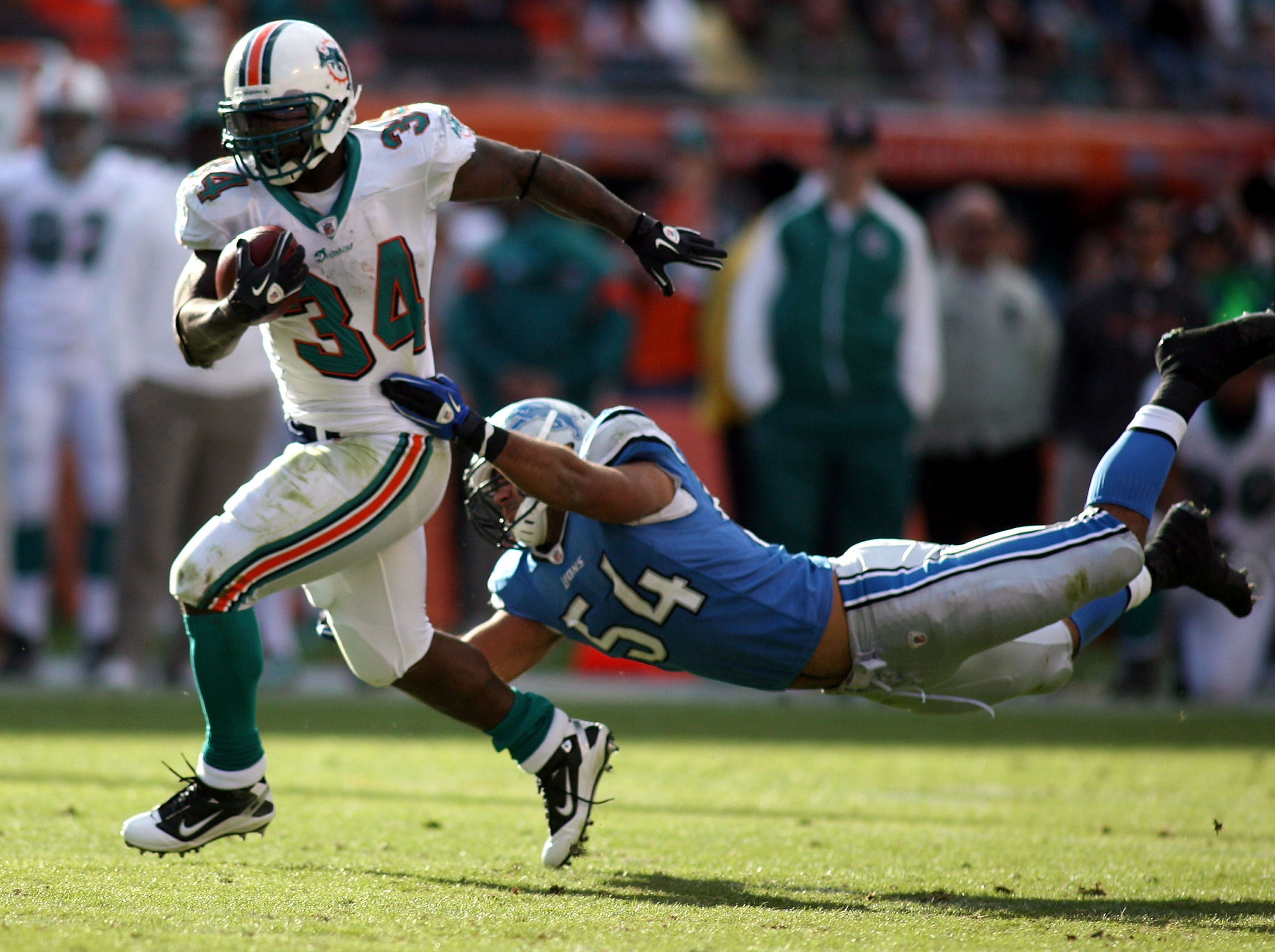 MIAMI - DECEMBER 26:  Running back Ricky Williams #34 of the Miami Dolphins breaks away from linebacker DeAndre Levy #54 of the Detroit Lions at Sun Life Stadium on December 26, 2010 in Miami, Florida. The Lions defeated the Dolphins 34-27.  (Photo by Mar