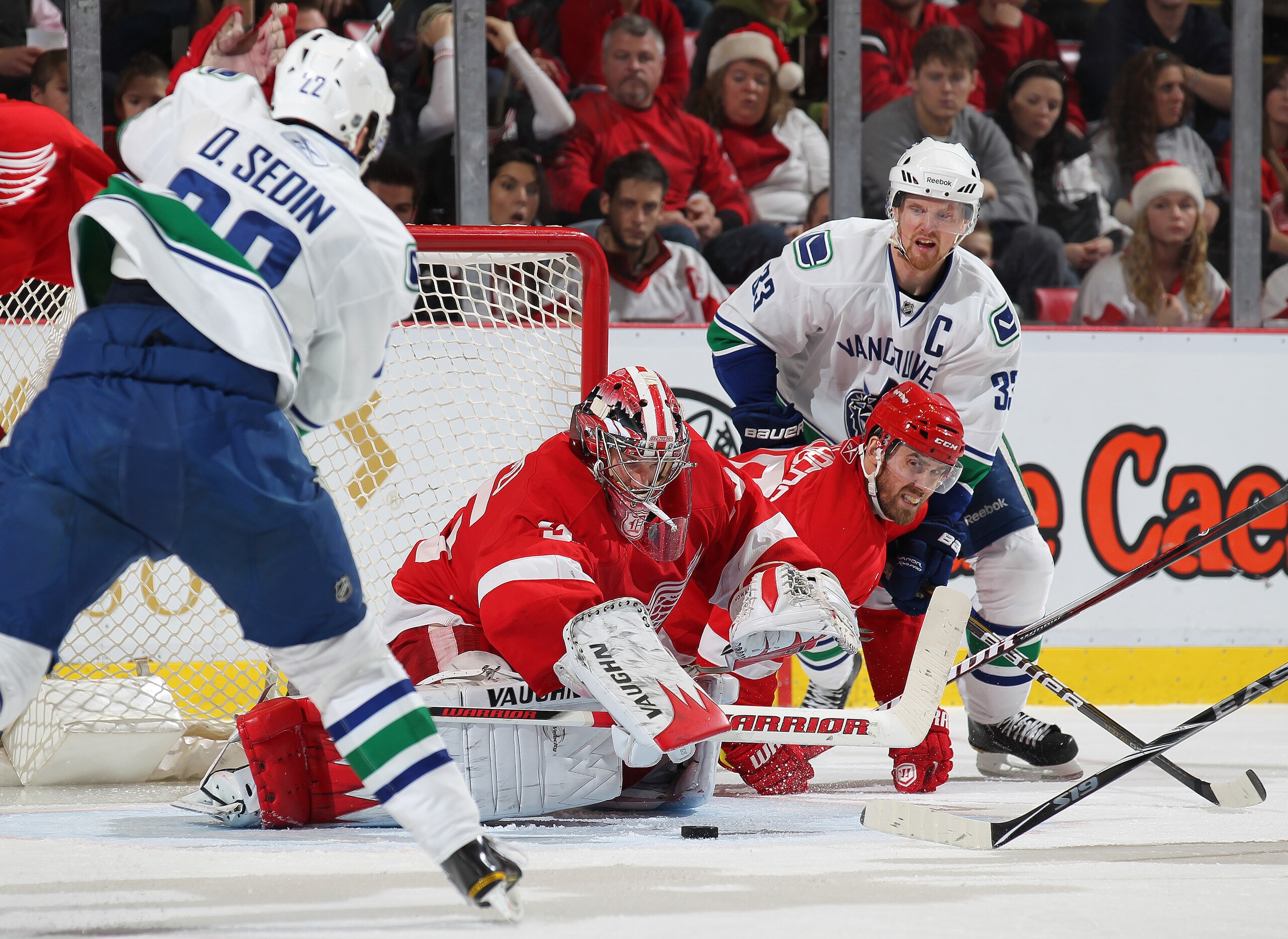 DETROIT, MI - DECEMBER 22:  Henrik Sedin #33 and Daniel Sedin #22 of the Vancouver Canucks press for a goal against Henrik Zetterberg #40 and Jimmy Howard #35 of the Detroit Red Wings in a game on December 22, 2010 at the Joe Louis Arena in Detroit, Michi