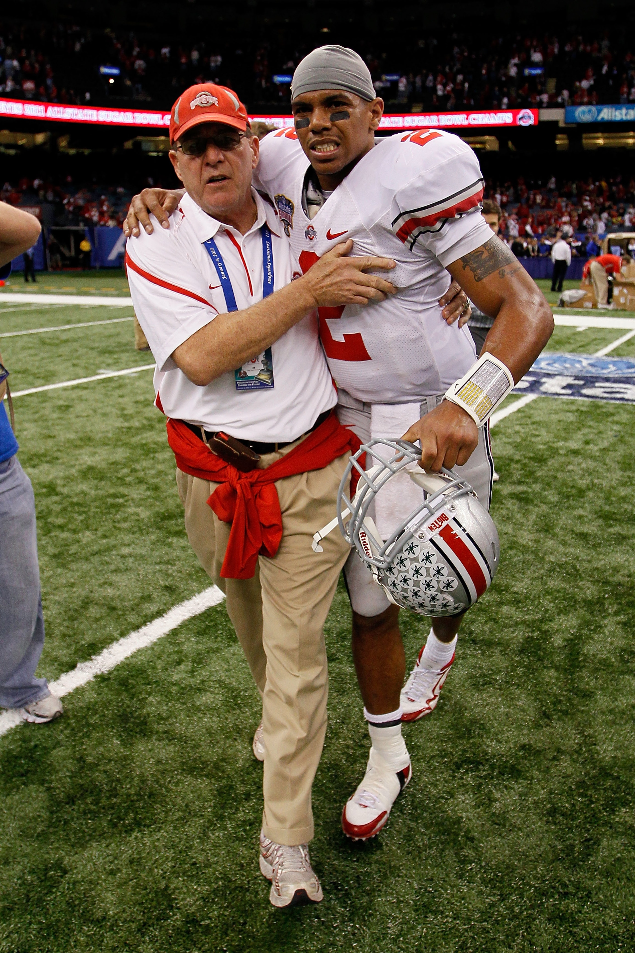 NEW ORLEANS, LA - JANUARY 04:  (M) Quarterback Terrelle Pryor #2 of the Ohio State Buckeyes is helped off the field by a member of the Buckeyes support team after the Buckeyes 31-26 victory against the Arkansas Razorbacks during the Allstate Sugar Bowl at