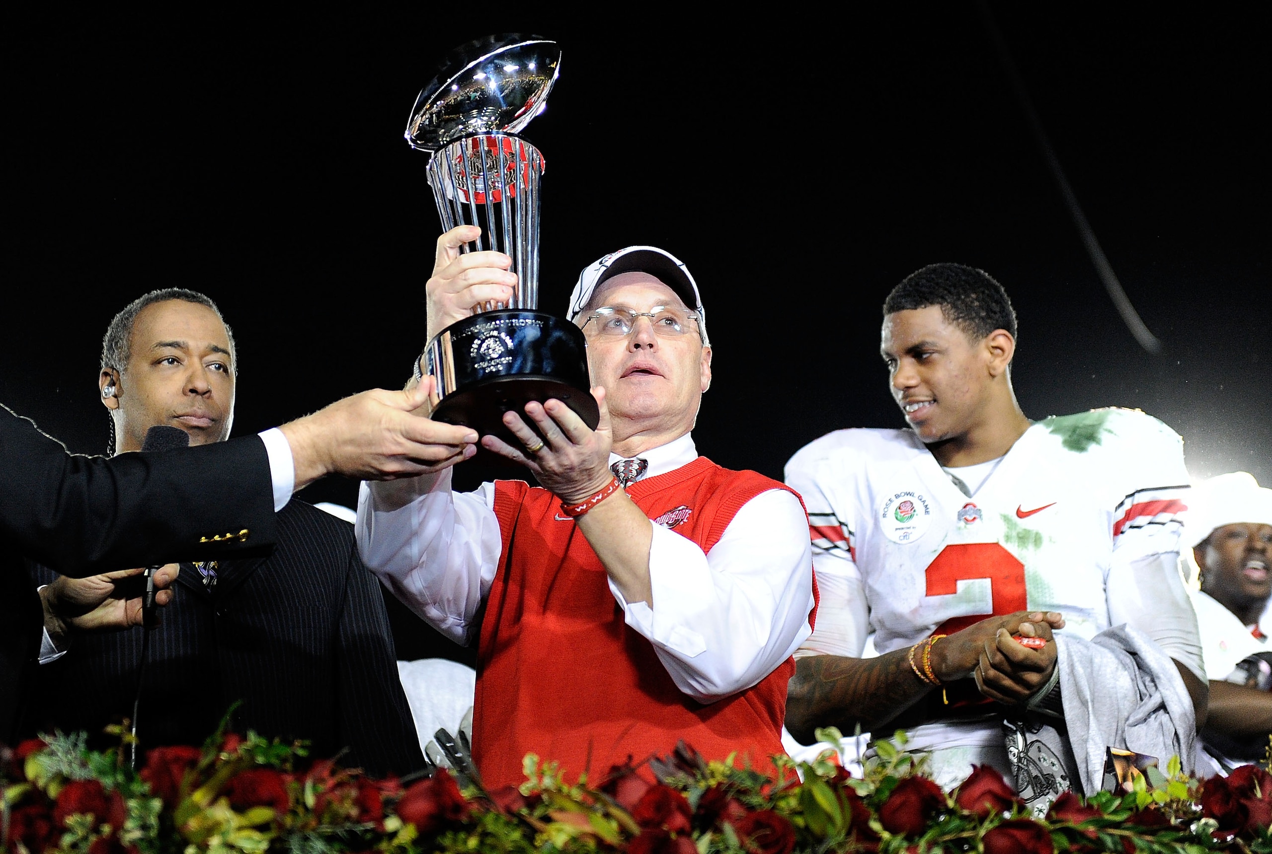 PASADENA, CA - JANUARY 01:  (C) Head coach Jim Tressel of the Ohio State Buckeyes celebrates with the Rose Bowl championship trophy as quarterback Terrelle Pryor #2 looks on after the buckeyes 26-17 win in the 96th Rose Bowl game over the Oregon Ducks on