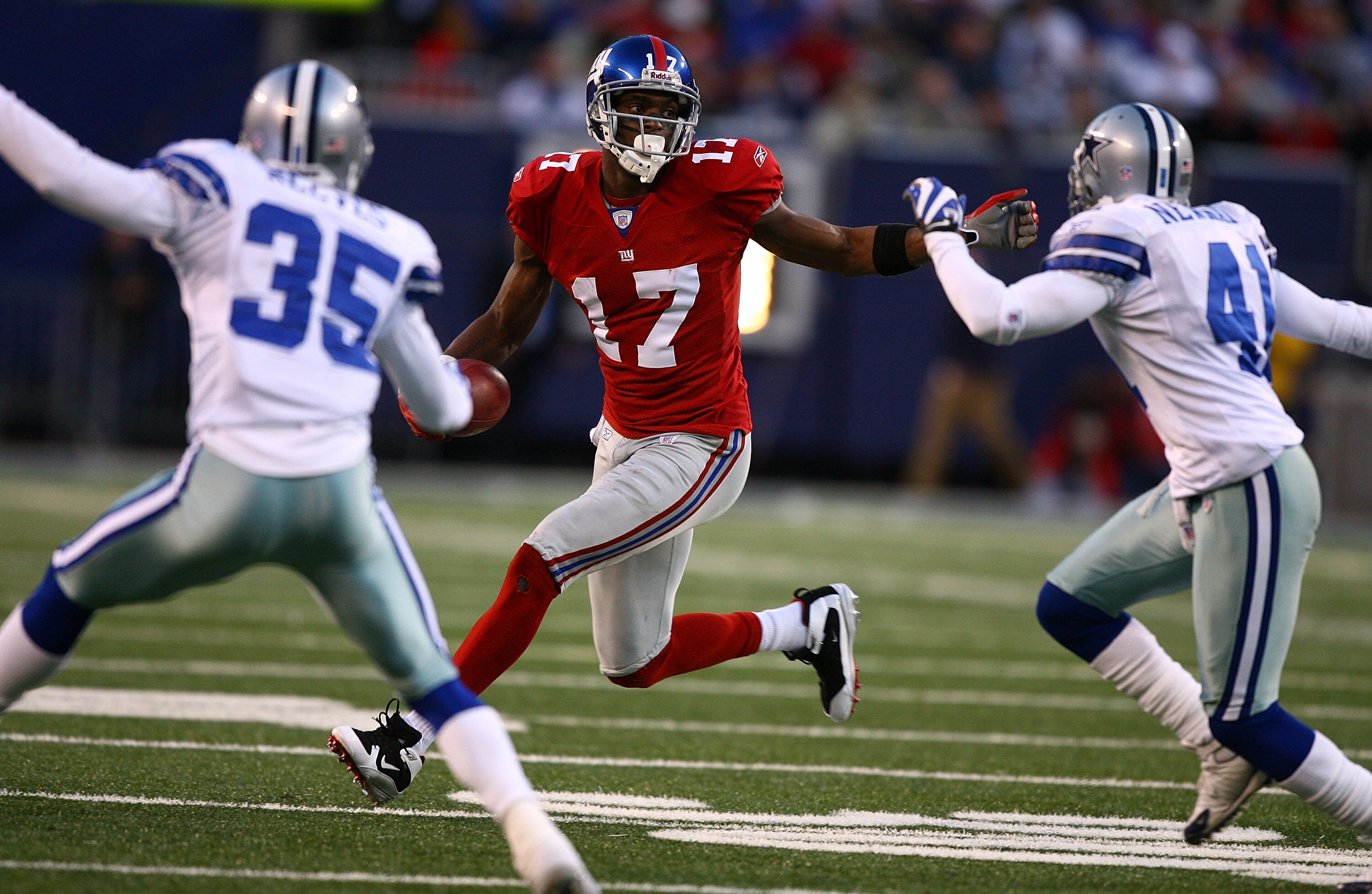 EAST RUTHERFORD, NJ - NOVEMBER 11:  Plaxico Burress #17 of the New York Giants looks for room to run as Jacques Reeves #35 and Terrence Newman #41 of the Dallas Cowboys close in during their game at Giants Stadium November 11, 2007 in East Rutherford, New