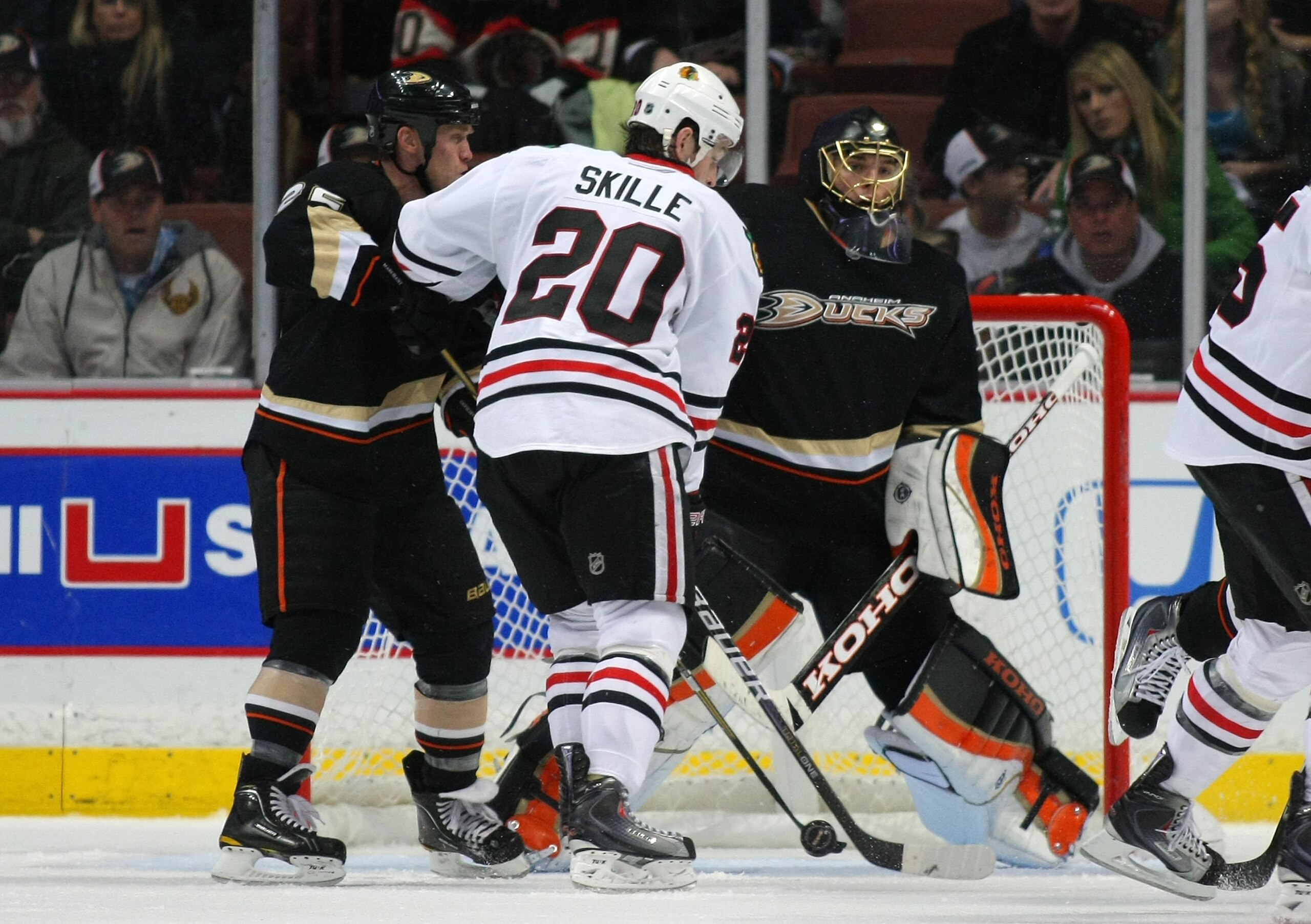 ANAHEIM, CA - JANUARY 02:  Goaltender Jonas Hiller #1 of the Anaheim Ducks tries to find the puck as teammate Todd Marchant #22 defends Jack Skille #20 of the Chicago Blackhawks in the crease area in the third period during the NHL game at Honda Center on