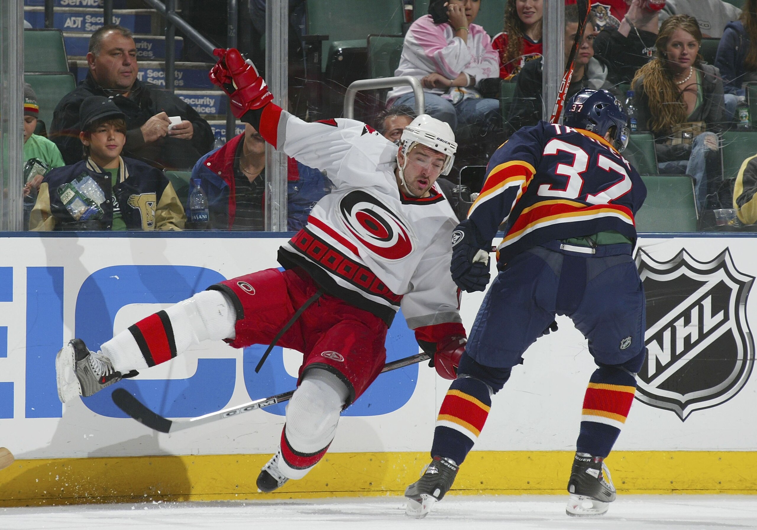 SUNRISE, FL - JANUARY 25:  Justin Williams #11 of the Carolina Hurricanes falls to the ice after a hit from Petr Taticek #37 of the Florida Panthers on January 25, 2006 at the BankAtlantic Center in Sunrise, Florida.  (Photo by Bruce Bennett/Getty Images)