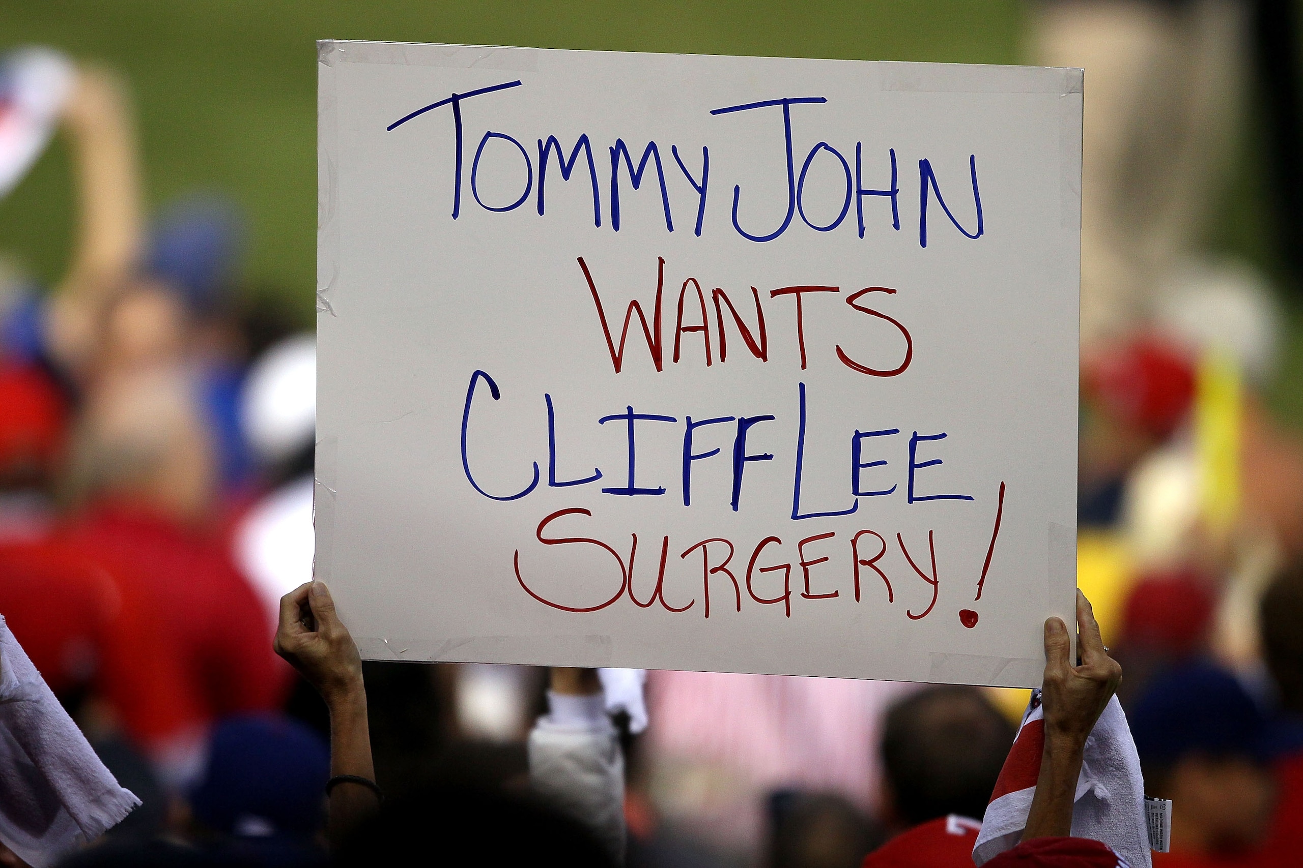 ARLINGTON, TX - NOVEMBER 01:  A fan of the Texas Rangers holds up a sign which reads Tommy John wants CLiff Lee Surgery against the San Francisco Giants in Game Five of the 2010 MLB World Series at Rangers Ballpark in Arlington on November 1, 2010 in Arli