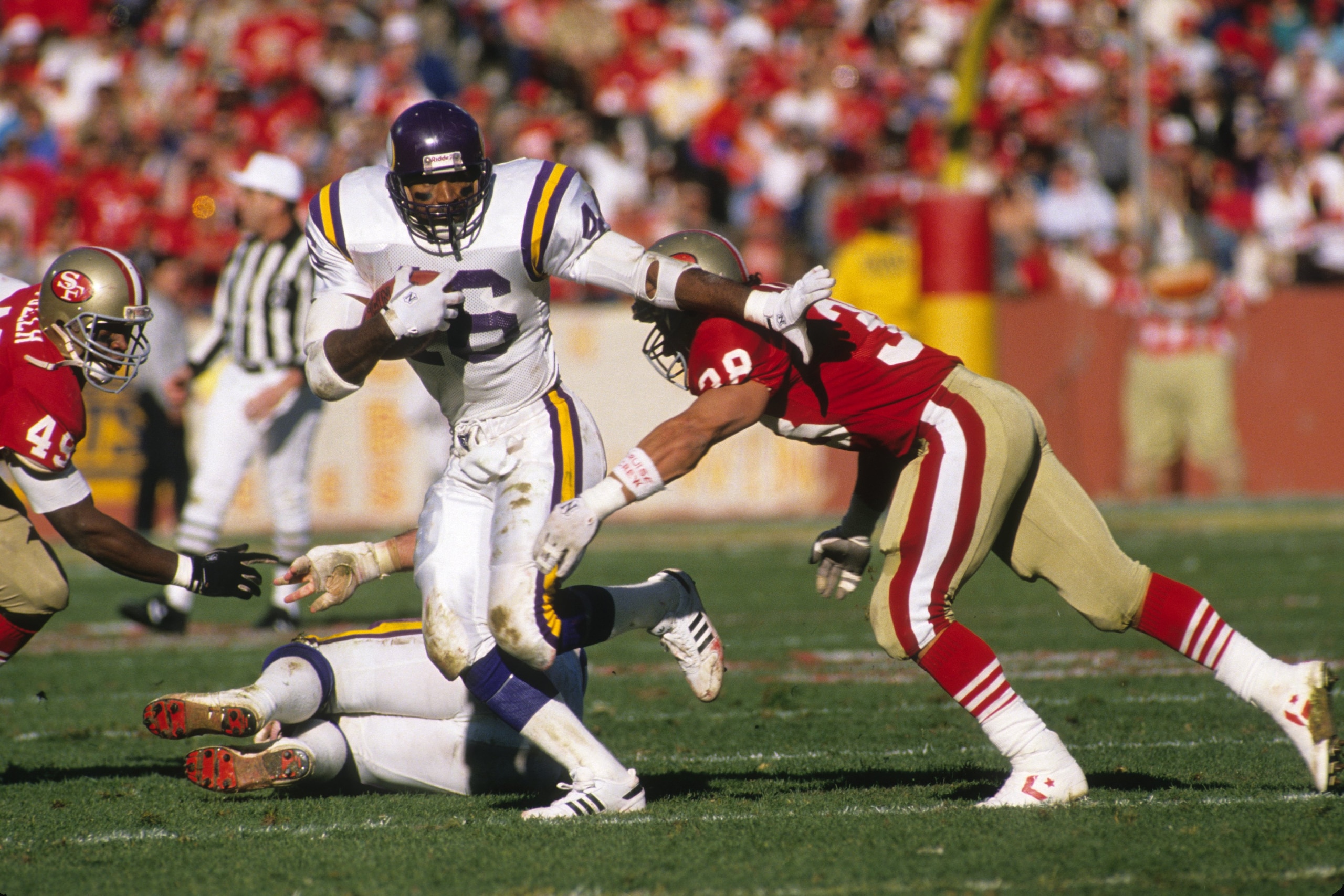 SAN FRANCISCO - JANUARY 1:  Running back Alfred Anderson #46 of the Minnesota Vikings looks for room to run against Jeff Fuller #49 and Greg Cox #38 of the San Francisco 49ers during the 1988 NFC Divisional Playoffs at Candlestick Park on January 1, 1989