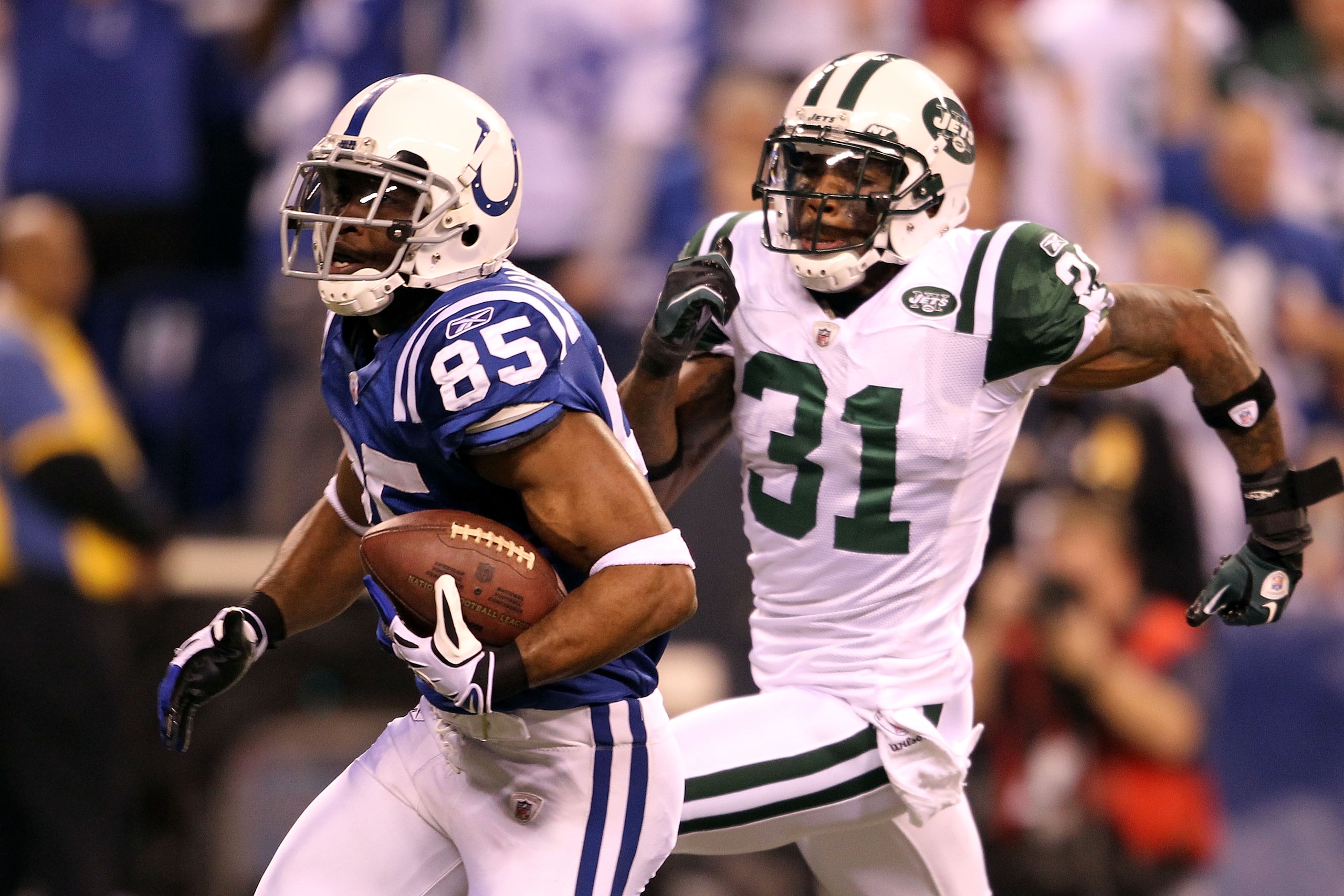 INDIANAPOLIS, IN - JANUARY 08:  Pierre Garcon #85 of the Indianapolis Colts scores on a 57-yard touchdown reception in the seocnd quarter against Antonio Cromartie #31 of the New York Jets during their 2011 AFC wild card playoff game at Lucas Oil Stadium