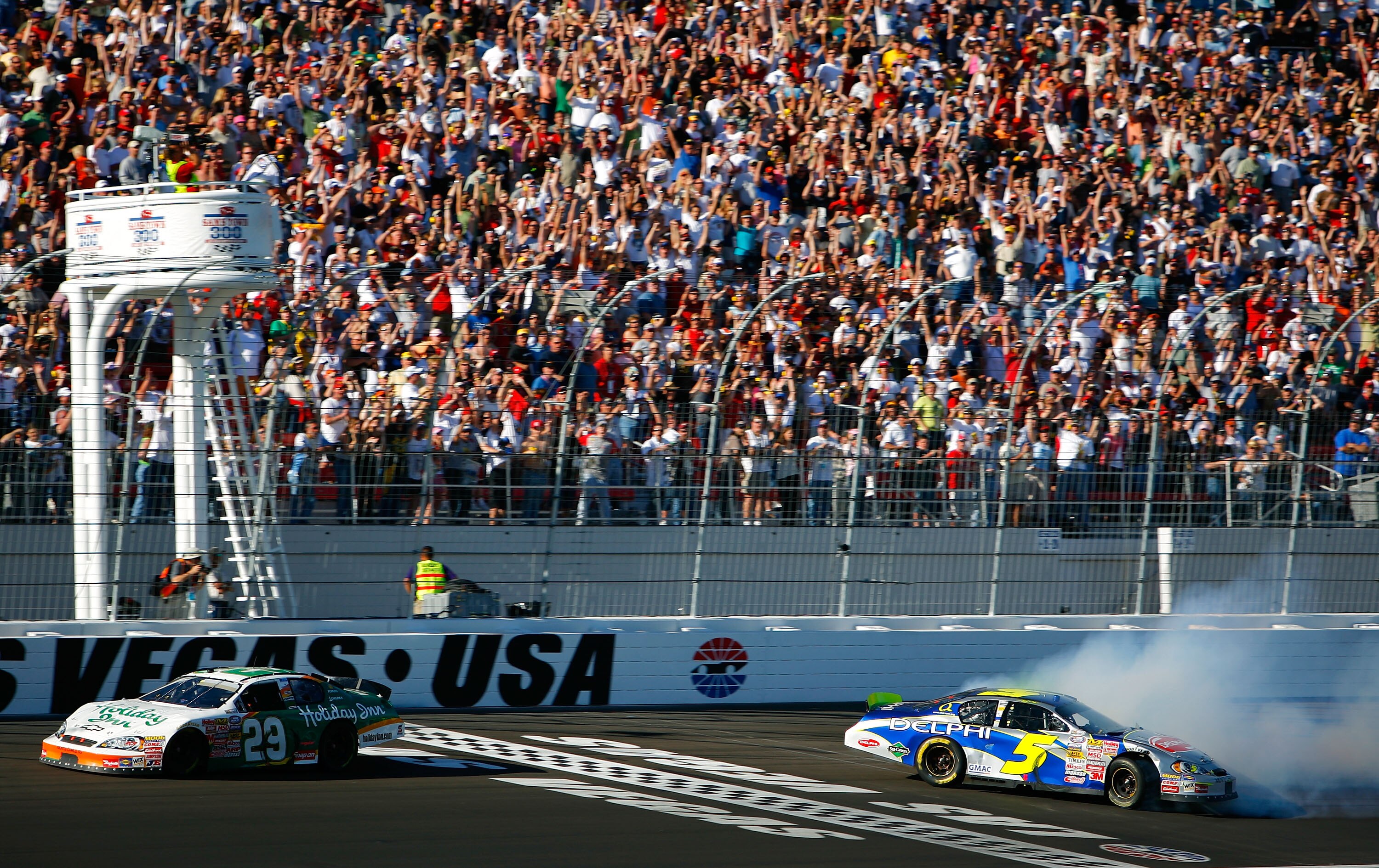 LAS VEGAS - MARCH 10:  Jeff Burton, driver of the #29 Holiday Inn Chevrolet, crosses the finish line to win the NASCAR Busch Series Sam's Town 300 at Las Vegas Motor Speedway as Kyle Busch, driver of the #5 Delphi Chevrolet, loses control of his car on Ma
