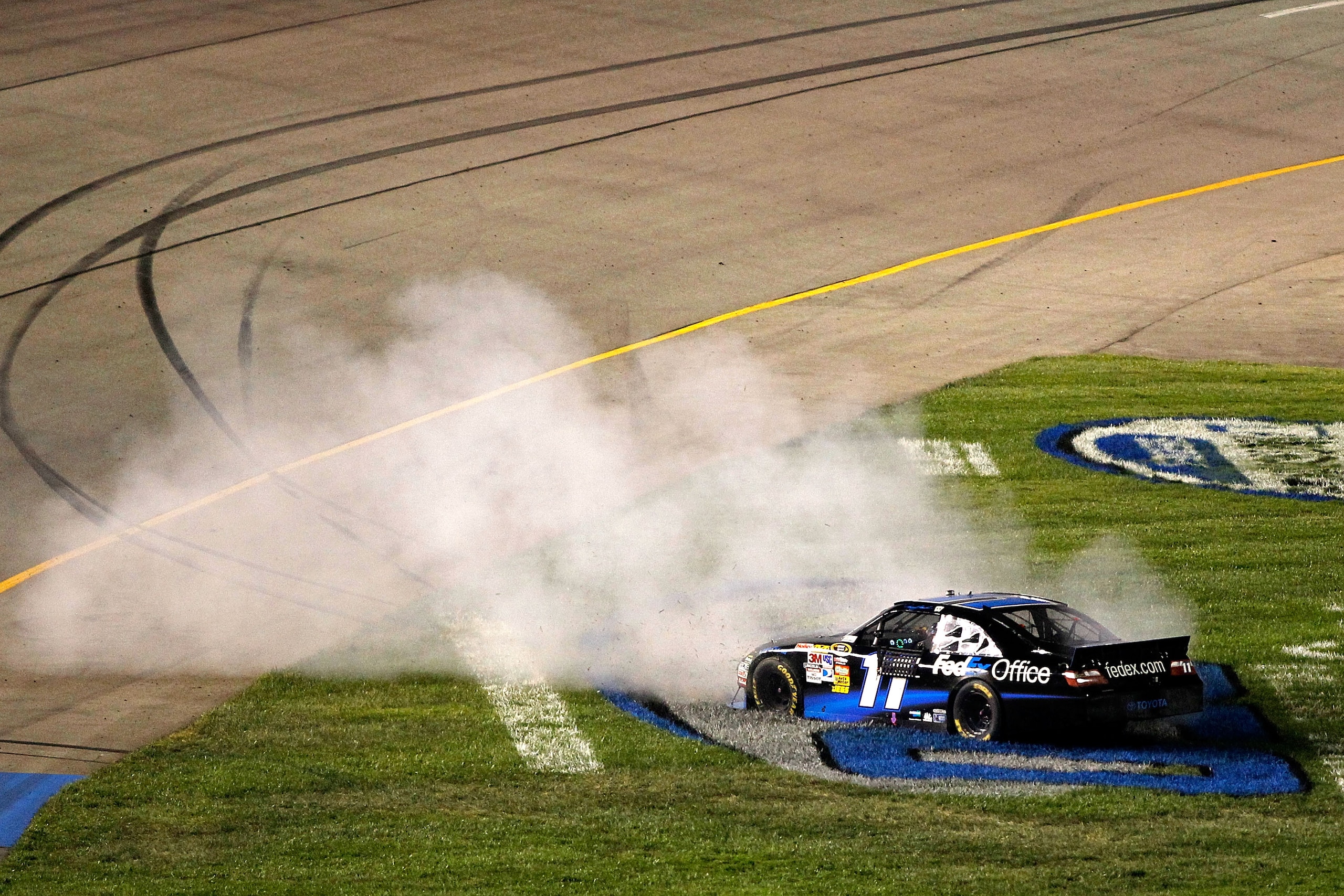 RICHMOND, VA - SEPTEMBER 11:  Denny Hamlin, driver of the #11 FedEx Office Toyota, performs a burnout to celebrate after winning the NASCAR Sprint Cup Series Air Guard 400 at Richmond International Raceway on September 11, 2010 in Richmond, Virginia.  (Ph