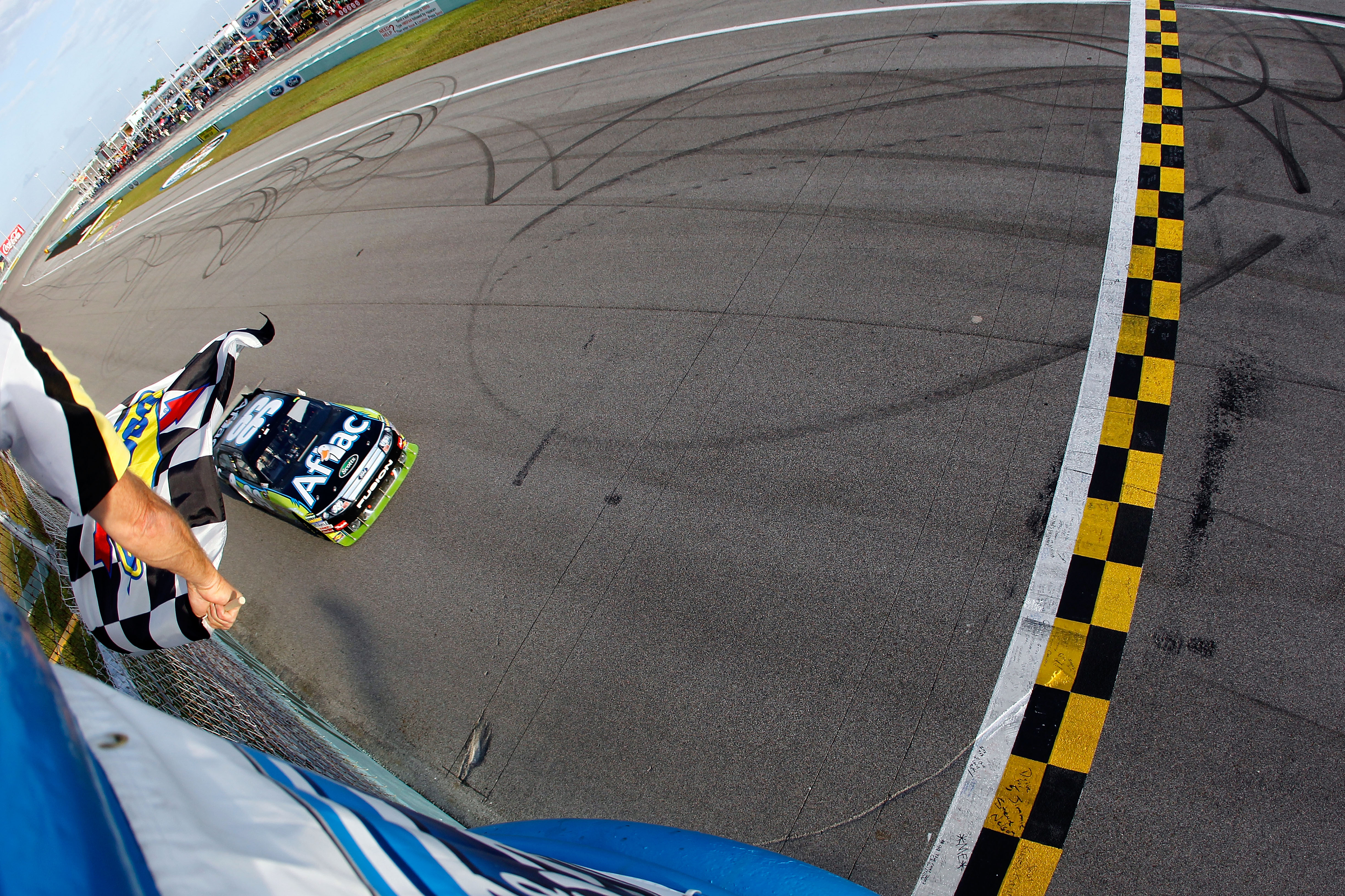HOMESTEAD, FL - NOVEMBER 21:  Carl Edwards, driver of the #99 Aflac Ford, takes the checkered flag to win the NASCAR Sprint Cup Series Ford 400 at Homestead-Miami Speedway on November 21, 2010 in Homestead, Florida.  (Photo by Todd Warshaw/Getty Images fo