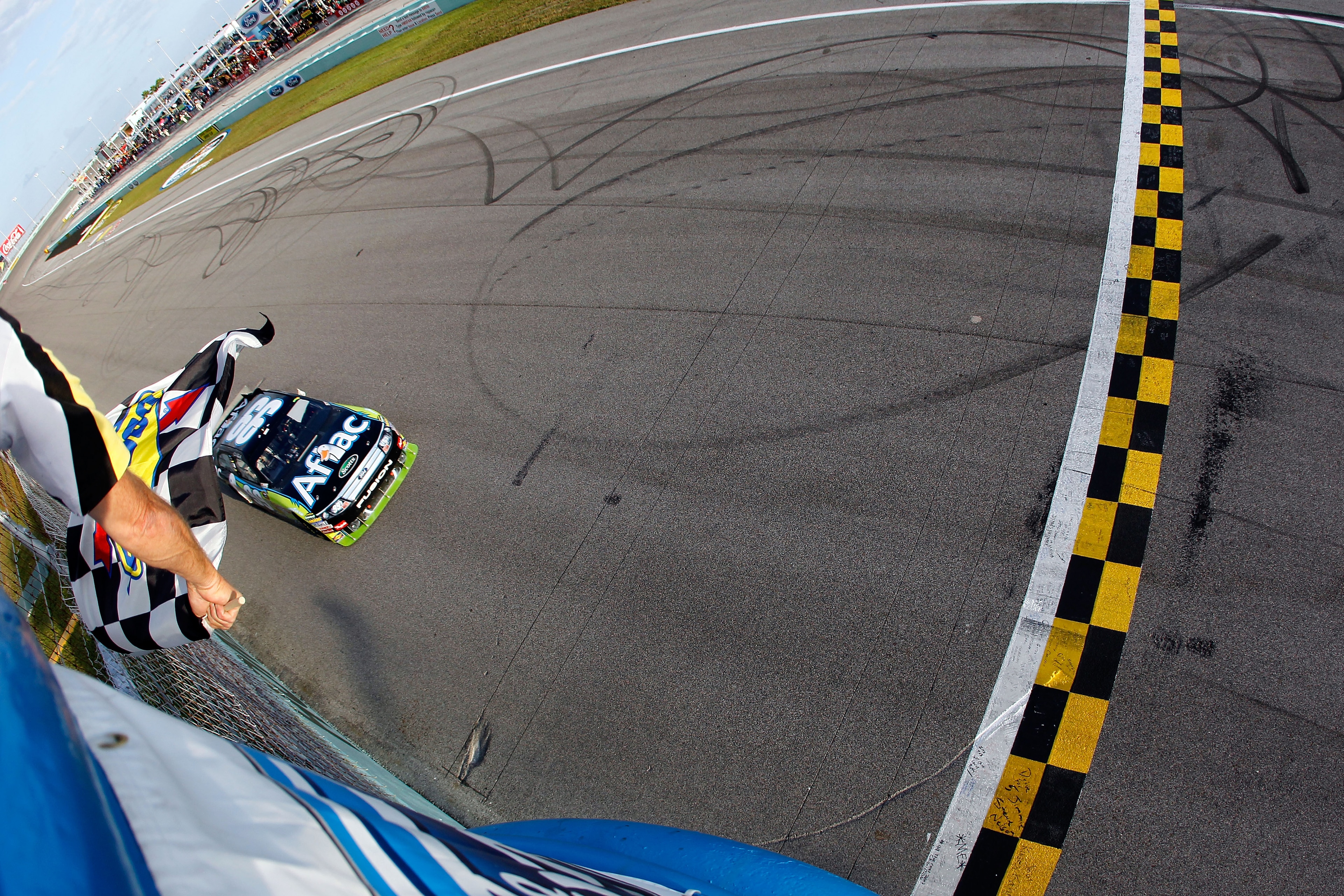 HOMESTEAD, FL - NOVEMBER 21: Carl Edwards, driver of the #99 Aflac Ford, takes the checkered flag to win the NASCAR Sprint Cup Series Ford 400 at Homestead-Miami Speedway on November 21, 2010 in Homestead, Florida. (Photo by Todd Warshaw/Getty Images fo HOMESTEAD, FL - NOVEMBER 21: Carl Edwards, driver of the #99 Aflac Ford, takes the checkered flag to win the NASCAR Sprint Cup Series Ford 400 at Homestead-Miami Speedway on November 21, 2010 in Homestead, Florida. (Photo by Todd Warshaw/Getty Images fo