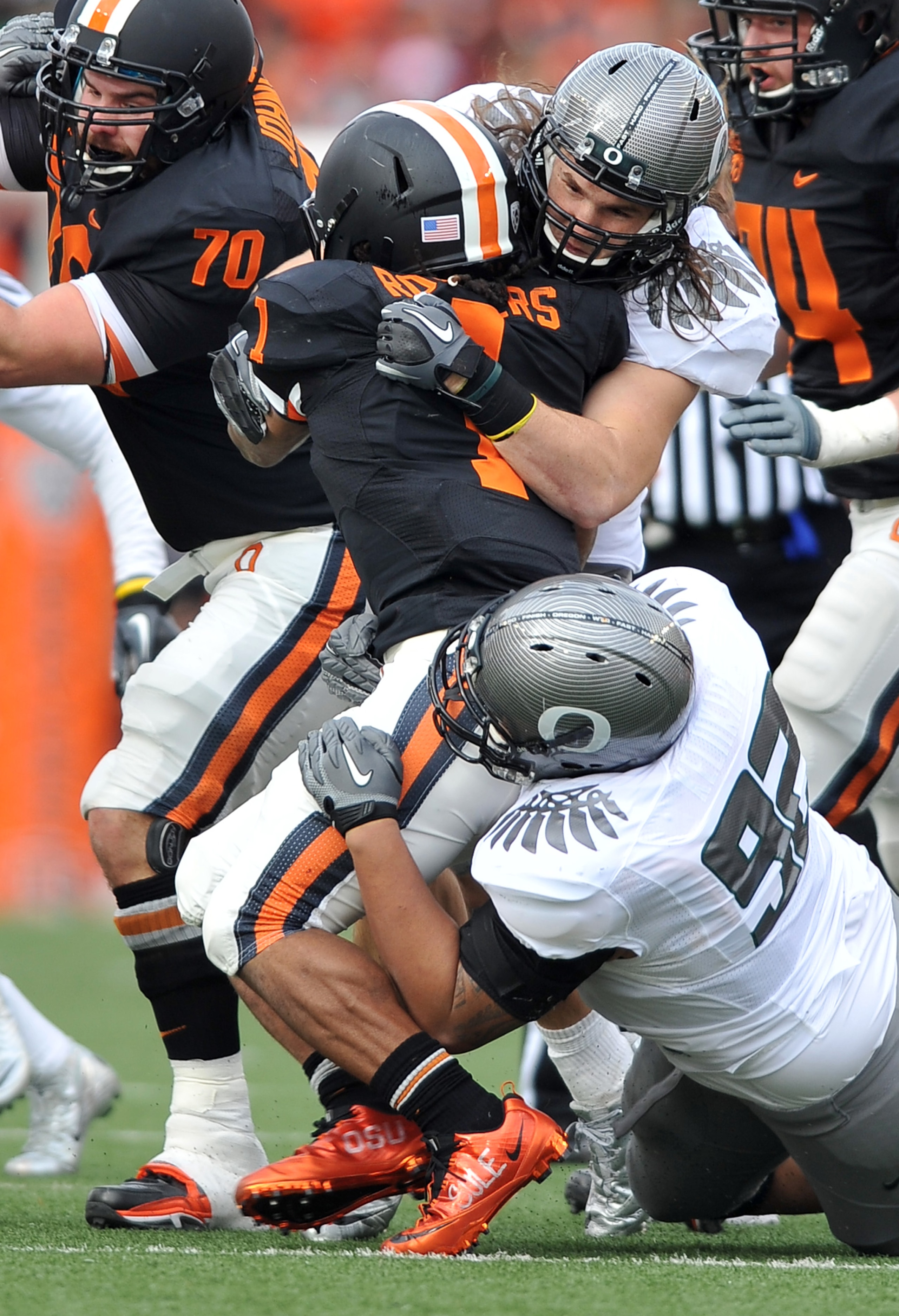 CORVALLIS, OR - DECEMBER 4: Jacquizz Rodgers #1 of the Oregon State Beavers is wrapped up by Casey Matthews #55 and Wade Keliikipi #92 of the Oregon Ducks in the first quarter of the game at Reser Stadium on December 4, 2010 in Corvallis, Oregon. The Duck