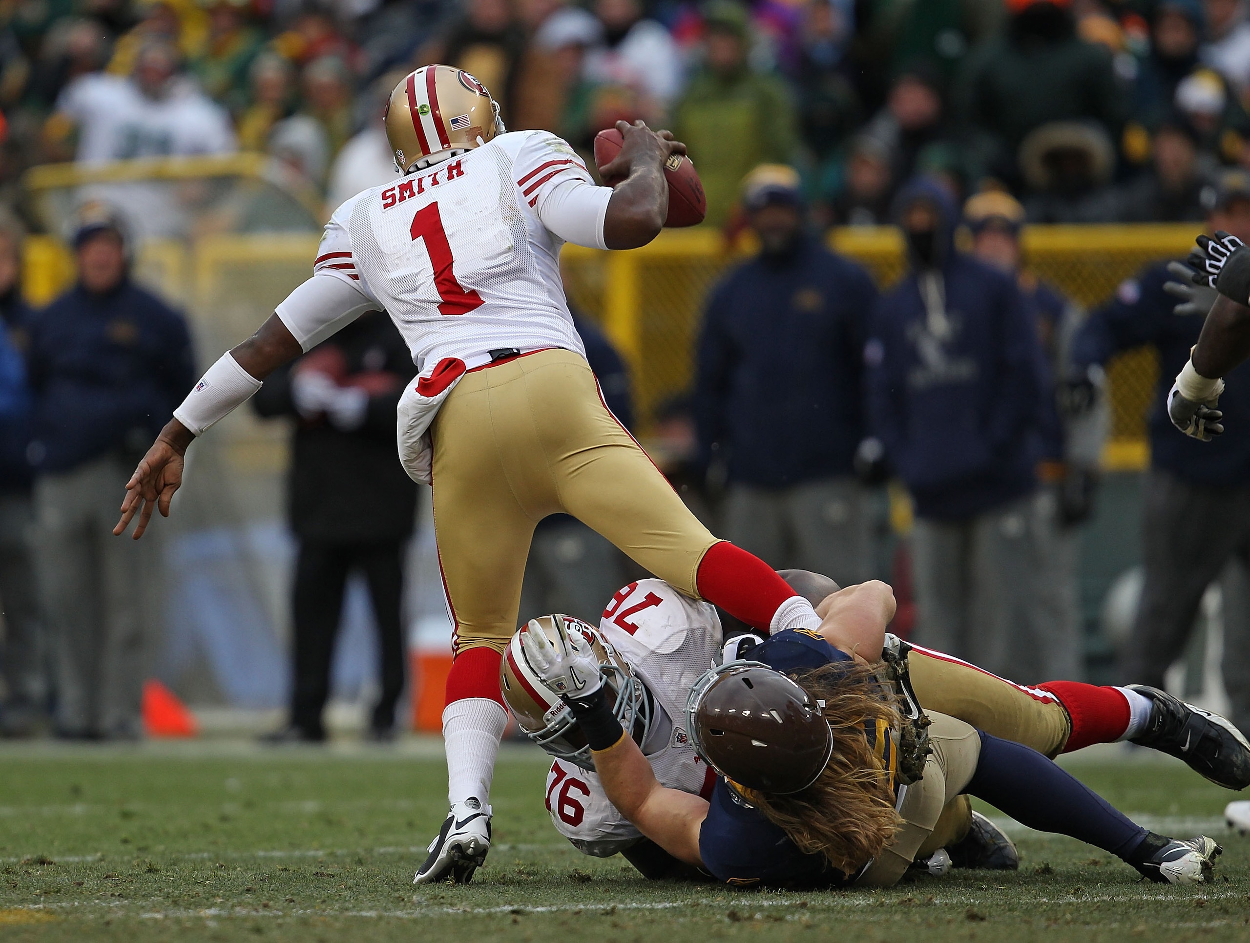 GREEN BAY, WI - DECEMBER 05: Clay Matthews #52 of the Green Bay Packers grabs the leg of Troy Smith #1 of the San Francisco 49ers in an effort to bring him down as Anthony Davis #76 tries to hold him off at Lambeau Field on December 5, 2010 in Green Bay, GREEN BAY, WI - DECEMBER 05: Clay Matthews #52 of the Green Bay Packers grabs the leg of Troy Smith #1 of the San Francisco 49ers in an effort to bring him down as Anthony Davis #76 tries to hold him off at Lambeau Field on December 5, 2010 in Green Bay,