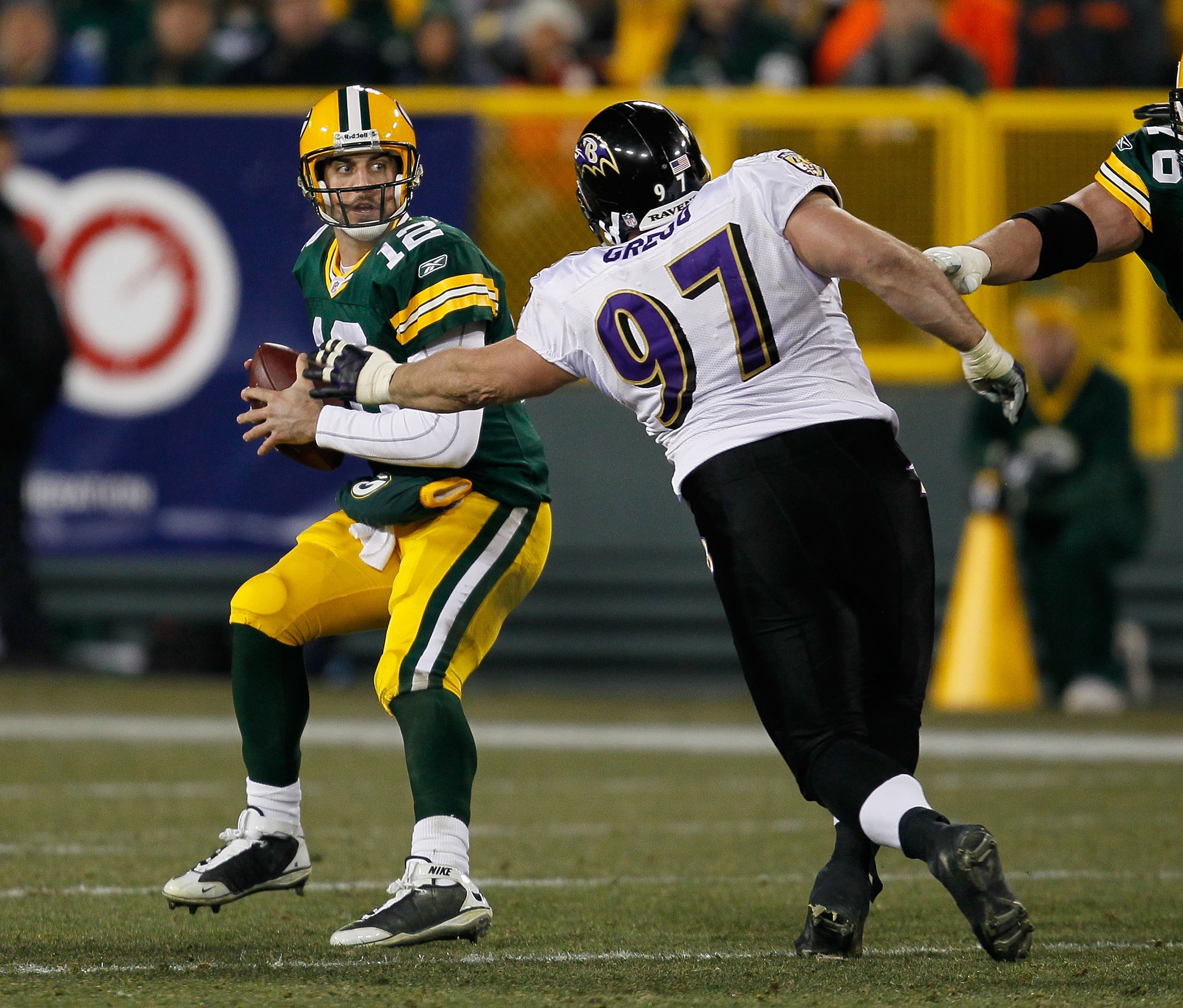 GREEN BAY, WI - DECEMBER 07: Aaron Rodgers #12 of the Green Bay Packers tries to escape from Kelly Gregg #97 of the Baltimore Ravens at Lambeau Field on December 7, 2009 in Green Bay, Wisconsin. The Packers defeated the Ravens 27-17. (Photo by Jonathan Da