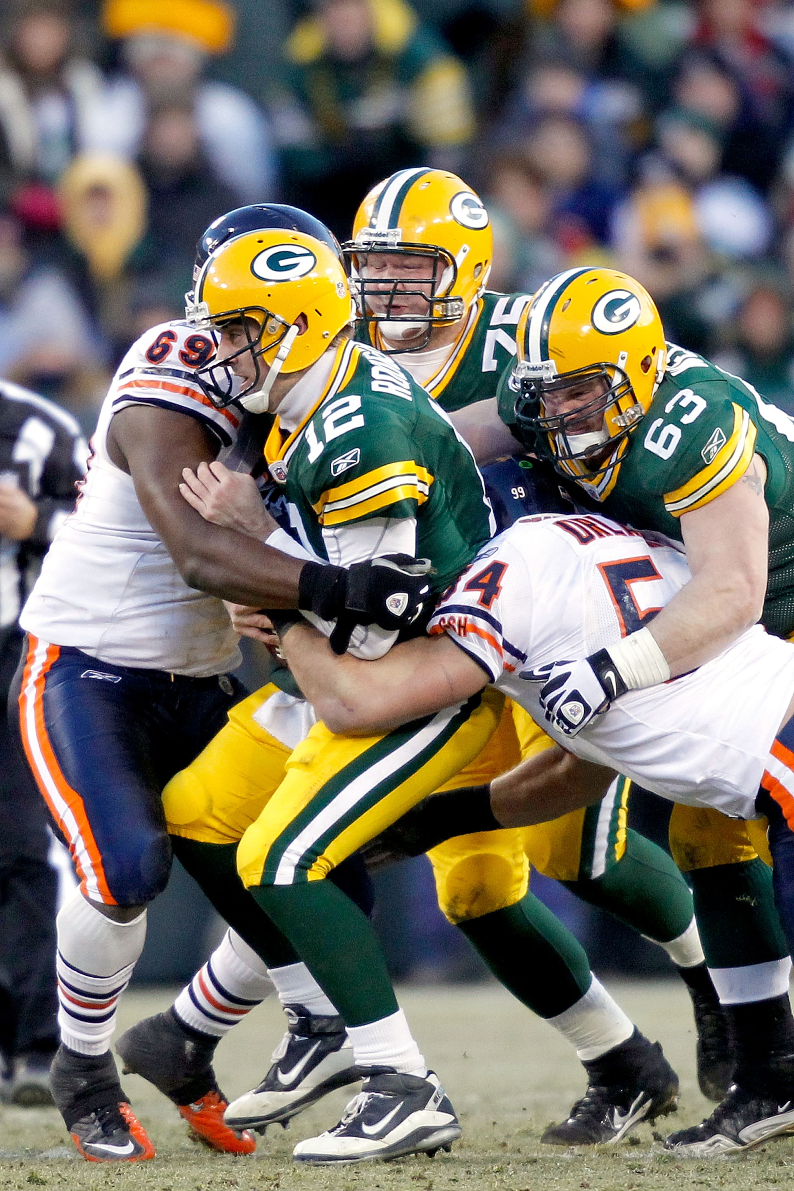 GREEN BAY, WI - JANUARY 02: Quarterback Aaron Rodgers #12 of the Green Bay Packers is sacked by Henry Melton #69 and Brian Urlacher #54 of the Chicago Bears at Lambeau Field on January 2, 2011 in Green Bay, Wisconsin. (Photo by Matthew Stockman/Getty Im GREEN BAY, WI - JANUARY 02: Quarterback Aaron Rodgers #12 of the Green Bay Packers is sacked by Henry Melton #69 and Brian Urlacher #54 of the Chicago Bears at Lambeau Field on January 2, 2011 in Green Bay, Wisconsin. (Photo by Matthew Stockman/Getty Im