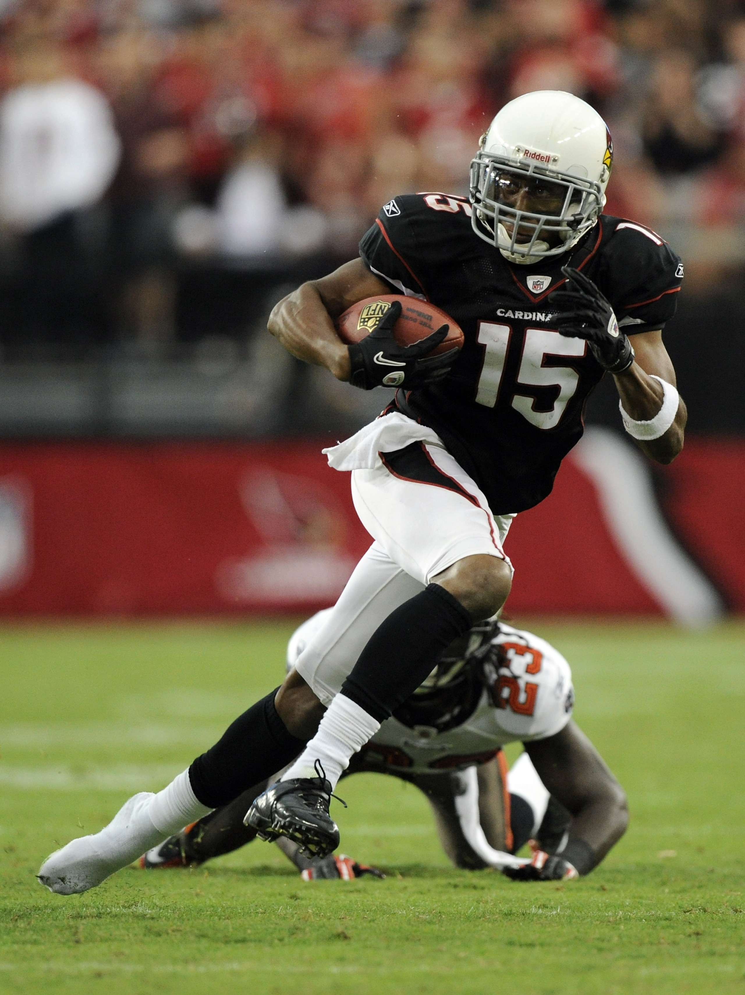 GLENDALE, AZ - OCTOBER 31:  Steve Breaston #15 of the Arizona Cardinals loses a shoe as he eludes the tackle from Myron Lewis #23 of the Tampa Bay Buccaneers during the fourth quarter at University of Phoenix Stadium on October 31, 2010 in Glendale, Arizo