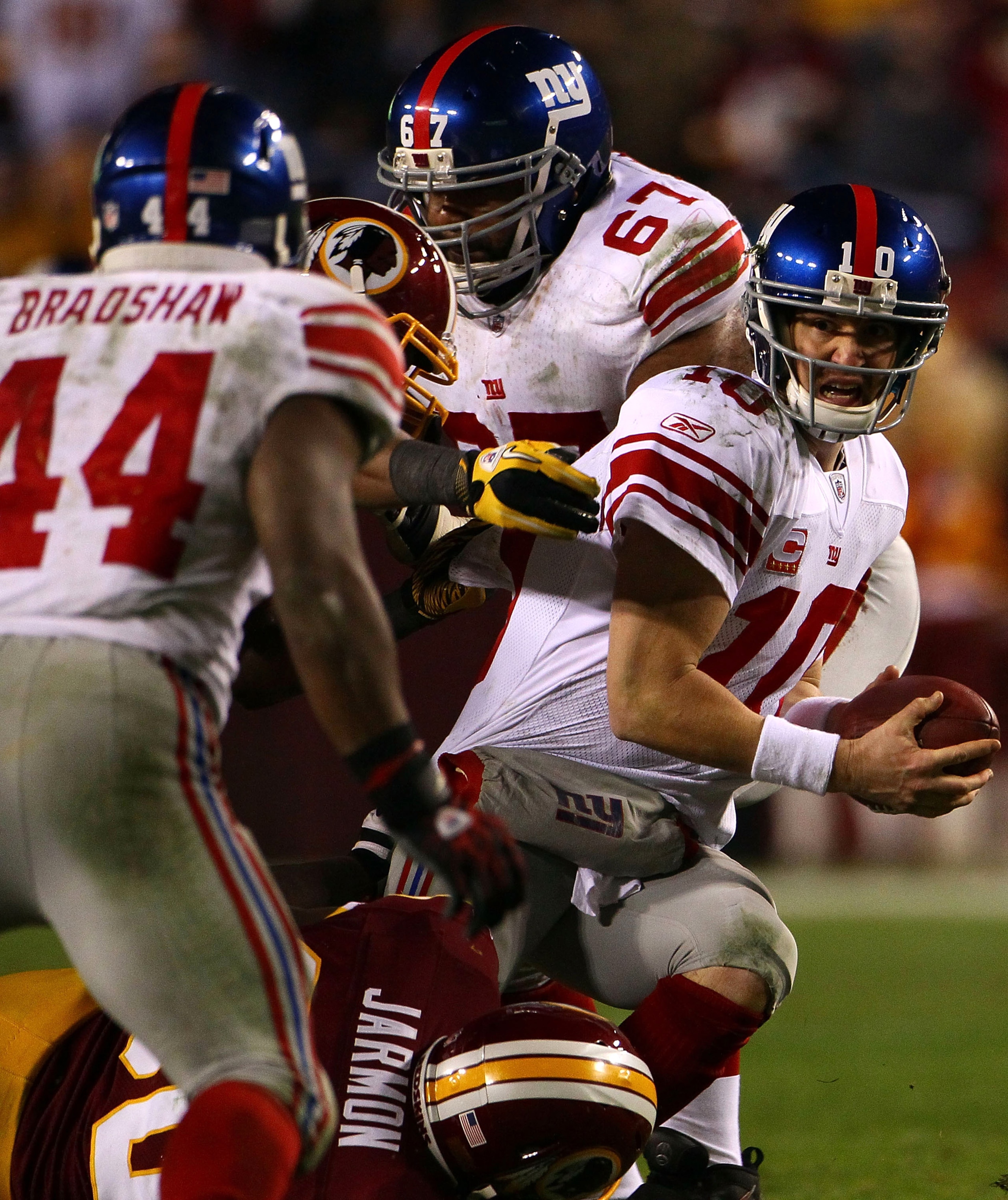 LANDOVER, MD - JANUARY 02: Quarterback Eli Manning #10 of the New York Giants looks to Ahmad Bradshaw to lateral the ball while being pressured by the Washington Redskins defense during their game at FedEx Field on January 2, 2011 in Landover, Maryland. LANDOVER, MD - JANUARY 02: Quarterback Eli Manning #10 of the New York Giants looks to Ahmad Bradshaw to lateral the ball while being pressured by the Washington Redskins defense during their game at FedEx Field on January 2, 2011 in Landover, Maryland.